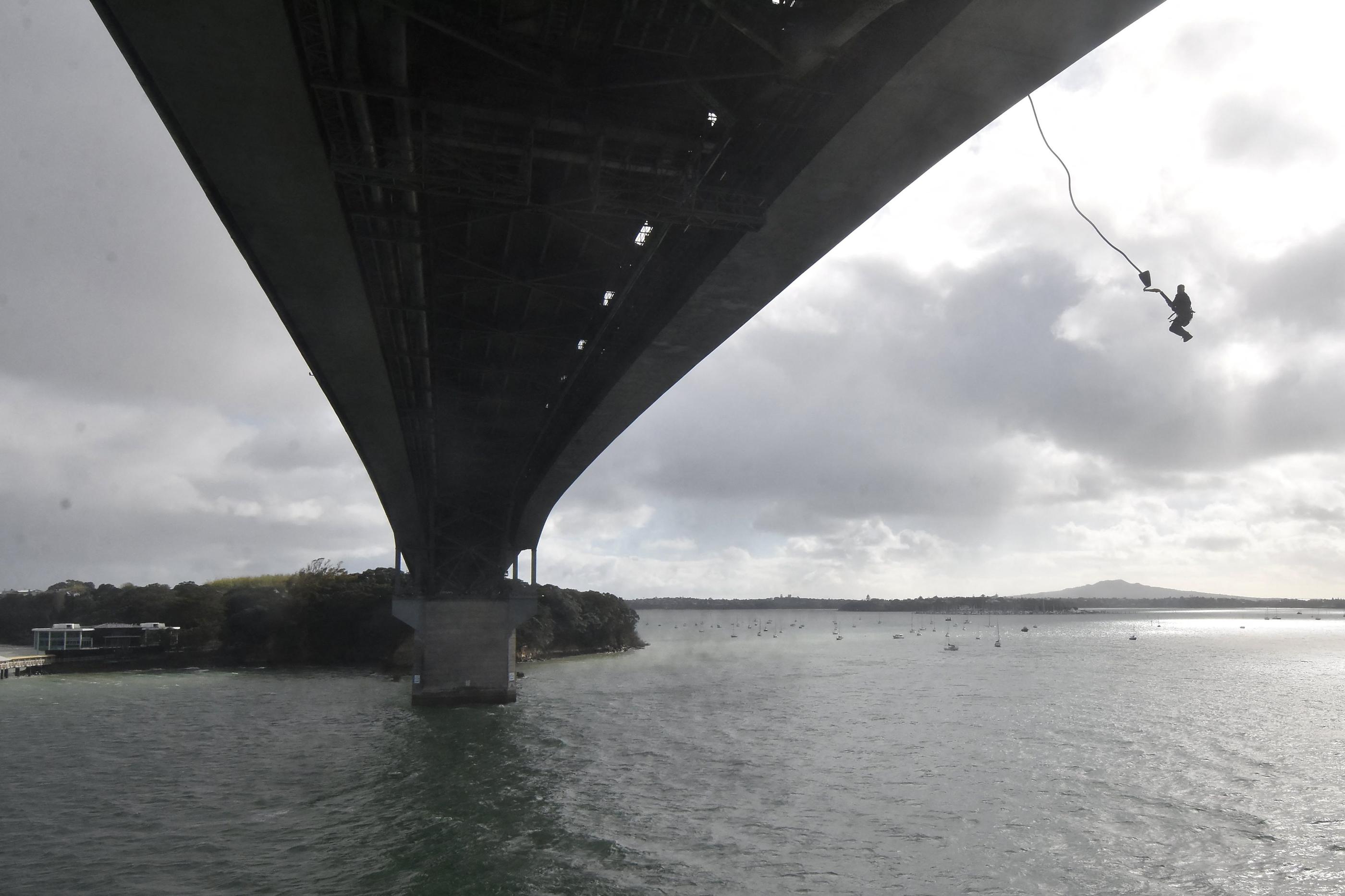 Une photo prise le 11 octobre 2023 montre Mike Heard sautant du "Bungy Pod" sur le Harbour Bridge à Auckland. Un Néo-Zélandais a battu le record du monde du plus grand nombre de sauts à l'élastique en 24 heures, après avoir effectué un total de 941 sauts depuis le pont d'Auckland..  AJ HACKETT BUNGY NEW ZEALAND / AFP