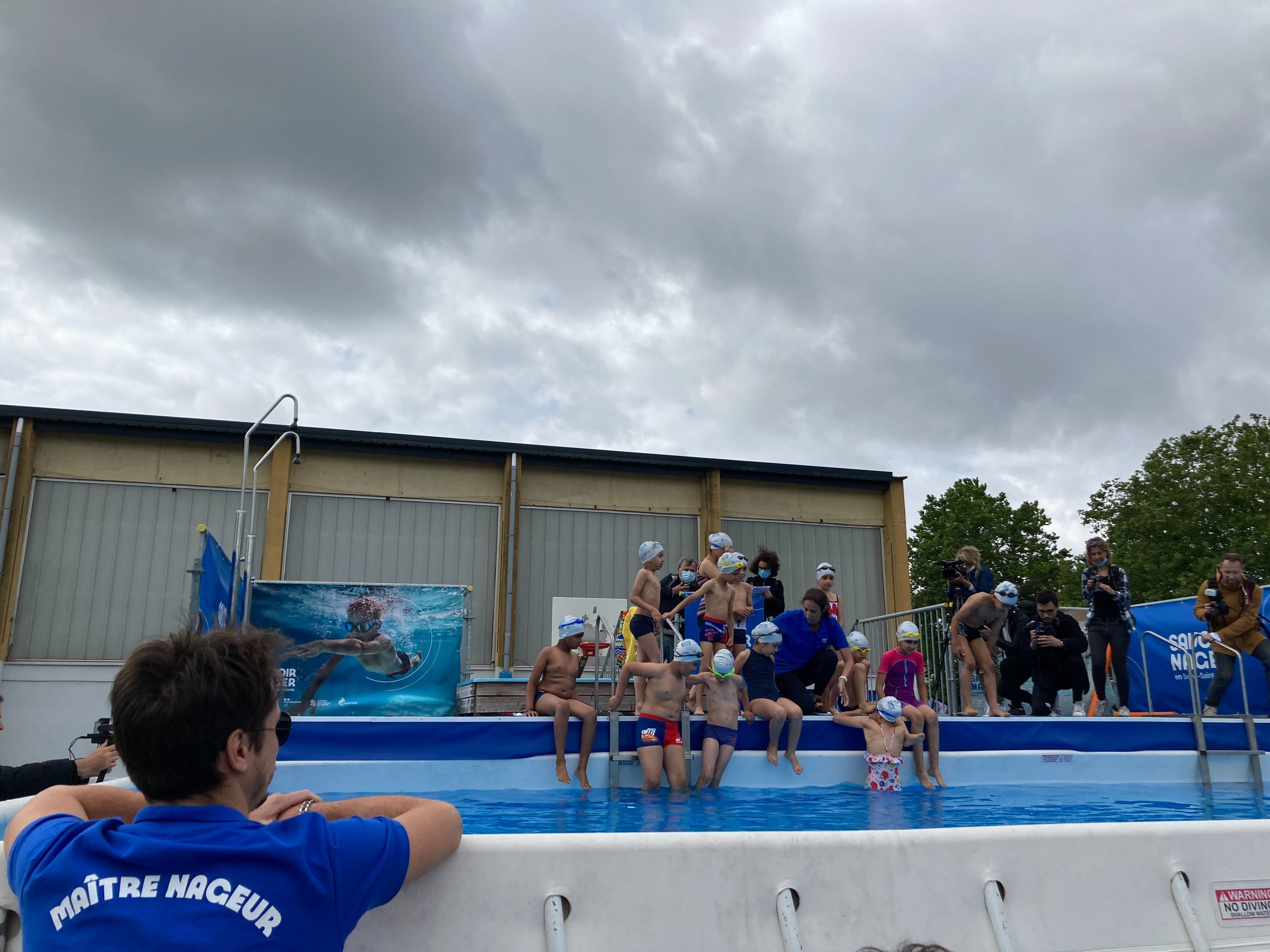 Clichy-sous-Bois (Seine-Saint-Denis), ce mardi.  Sous le regard de leur maître nageur comme de leurs parents, les enfants apprennent timidement à nager dans le bassin qui a été installé pour l'été. LP/C.L-T.