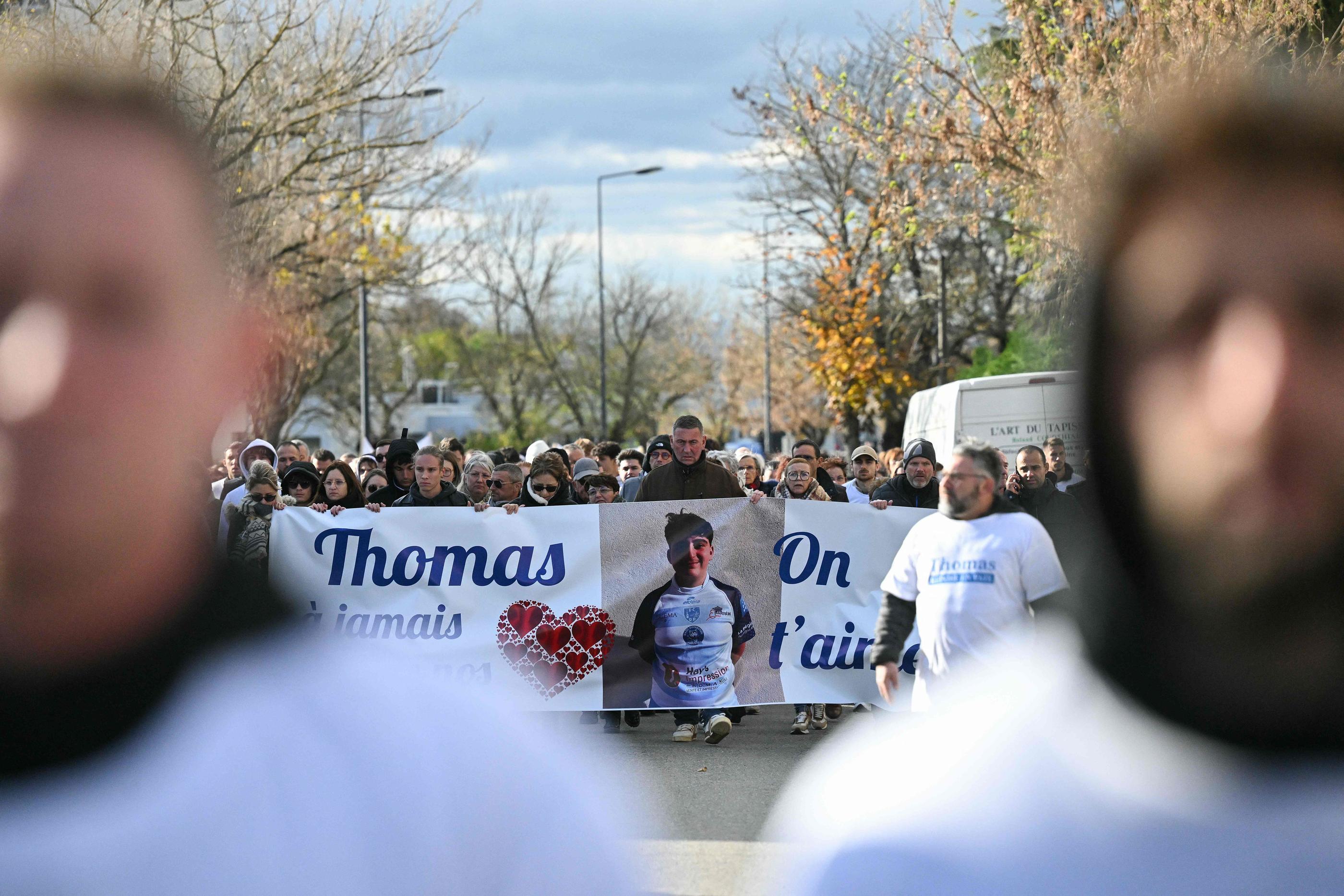 Le 22 novembre 2023, à Romans-sur-Isère, des personnes défilent derrière une banderole sur laquelle on peut lire "Thomas, dans nos cœurs à jamais, nous t'aimons". AFP/Olivier Chassignole