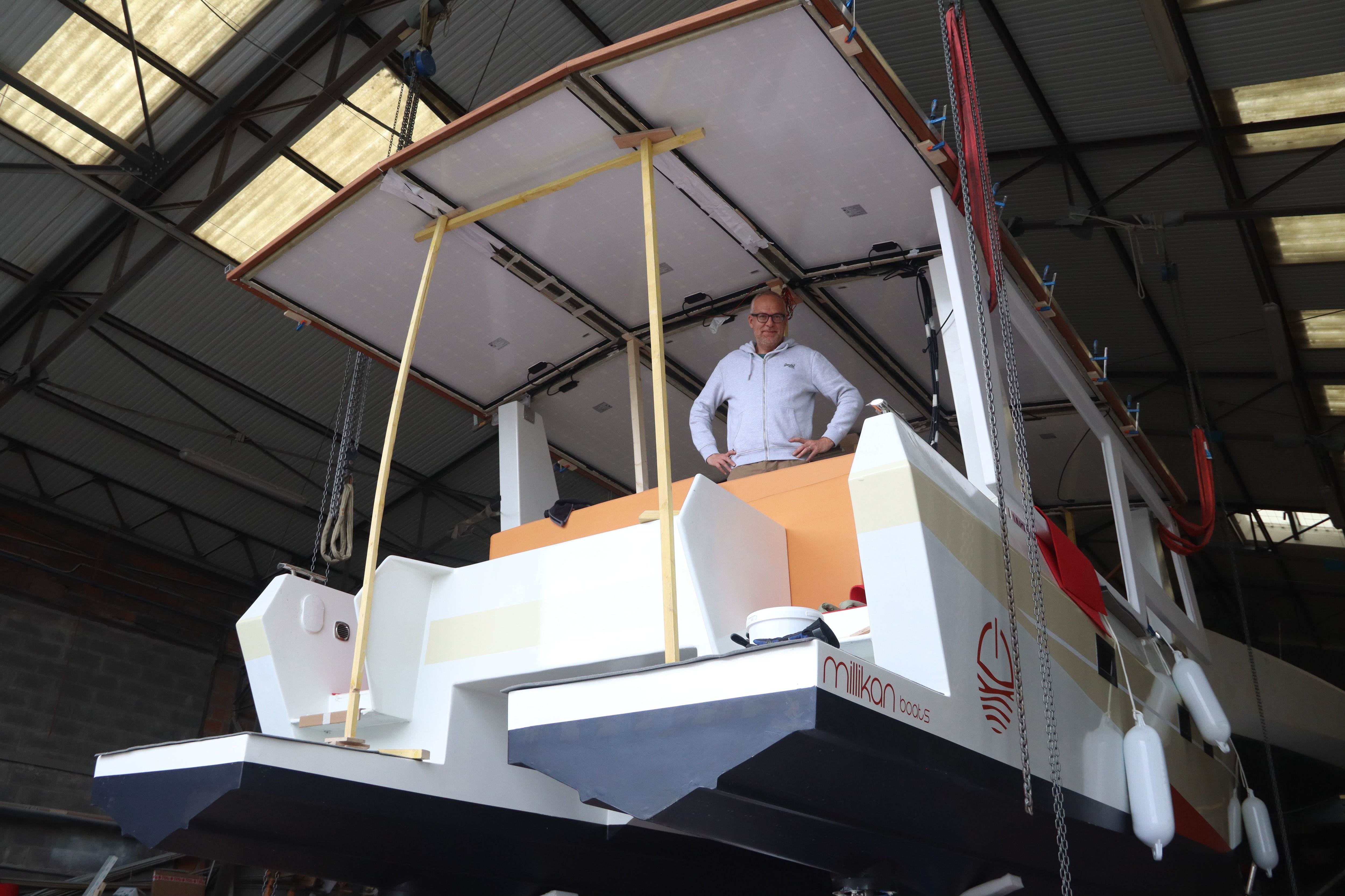 Philippe Raynaud sur Milikan, le catamaran électro-solaire qu'il construit depuis deux ans. Le bateau vient d'être mis à l'eau mais poursuit son développement sur le chantier à Caen. DR/Esteban Pinel