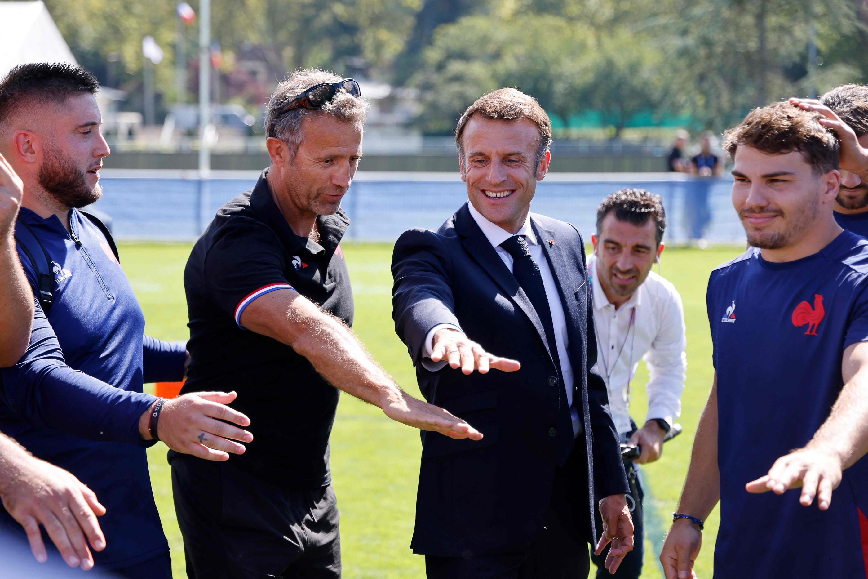Tout sourire, le président de la République Président Emmanuel Macron est venu ce lundi midi rendre visite aux Bleus de Fabien Galthié (2e en partant de la gauche) et d'Antoine Dupont (à droite) . (Photo Ludovic MARIN / POOL / AFP)