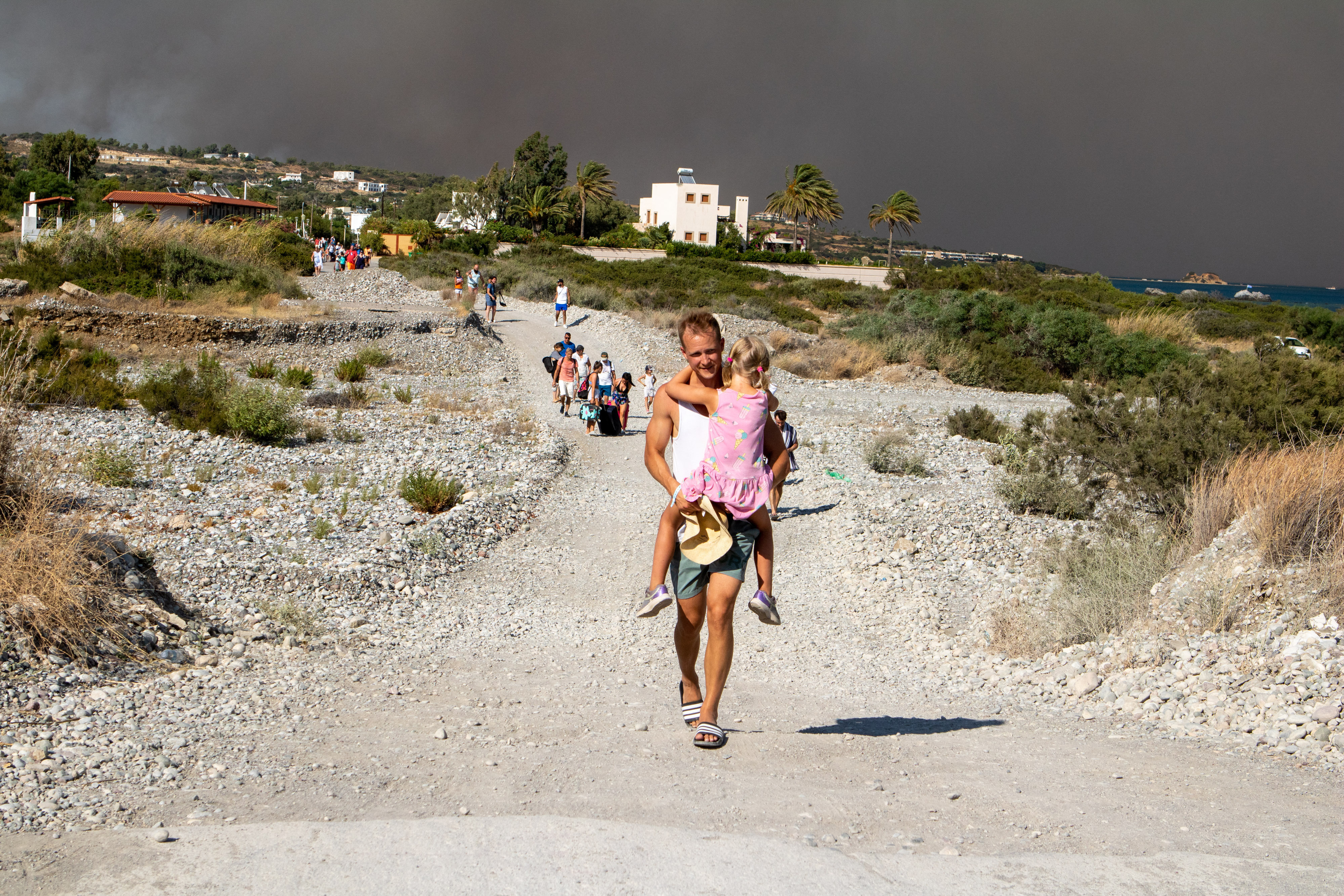 Sur l'île grecque de Rhodes, ce samedi, des milliers de touristes ont été évacués d'hôtels situés sur la côte sud-est face à la propagation des flammes. Anadolu Agency via AFP/Lefty Damian