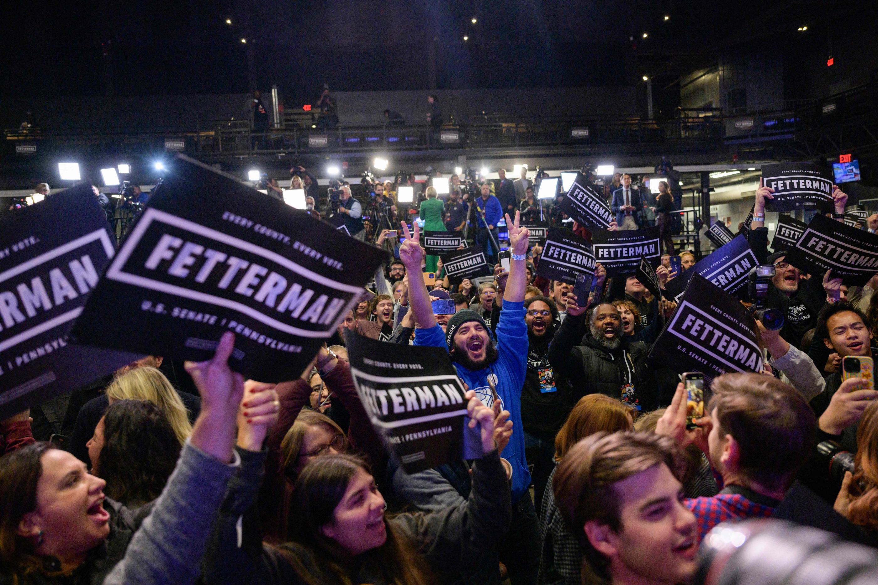 En Pennsylvanie, les supporters du démocrate John Fetterman fêtent sa victoire, remportée de justesse. AFP/ANGELA WEISS