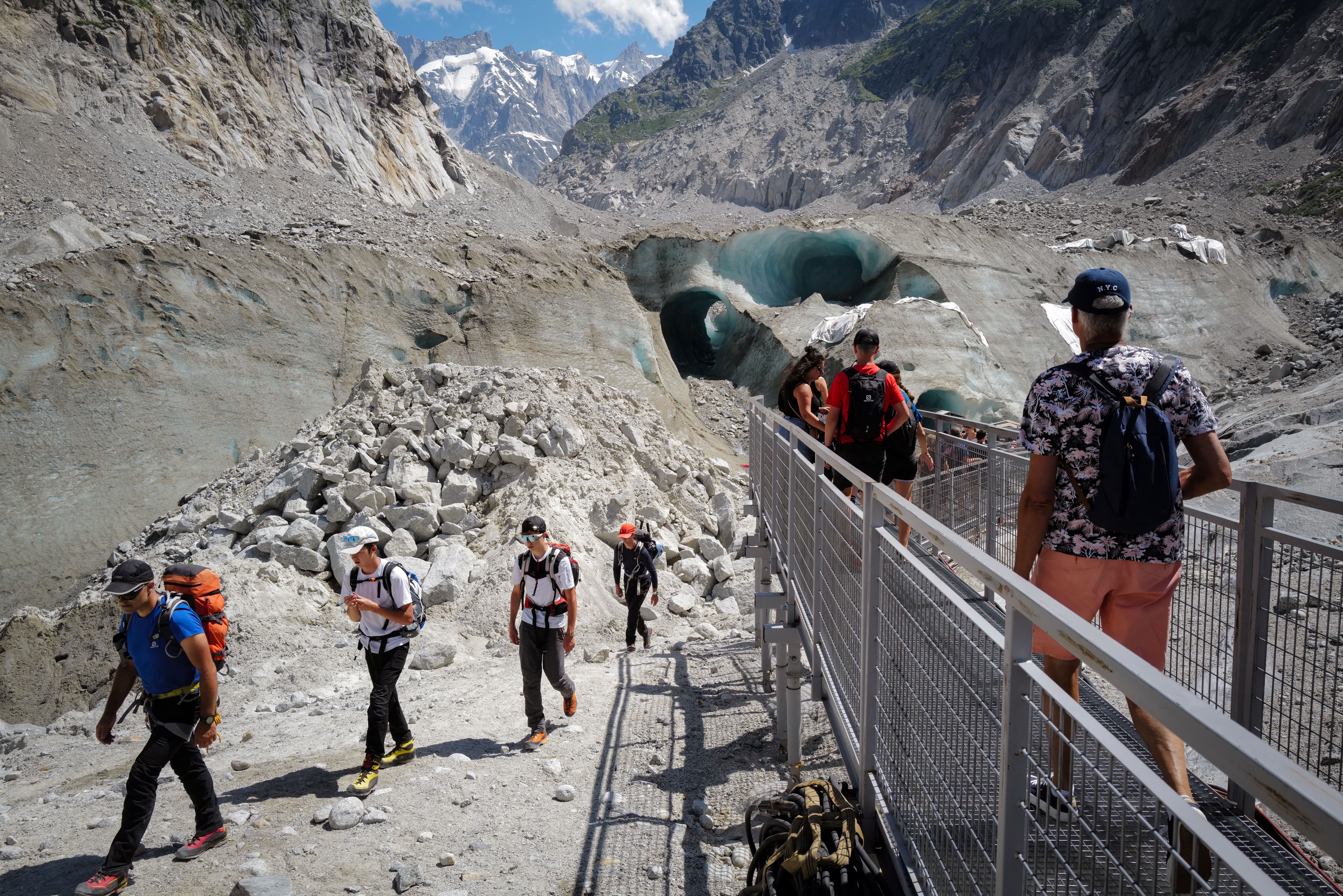 Chamonix (Haute-Savoie), le 11 juillet. Des visiteurs empruntent un pont pour accéder à la grotte de glace. AFP/Olivier Chassignole