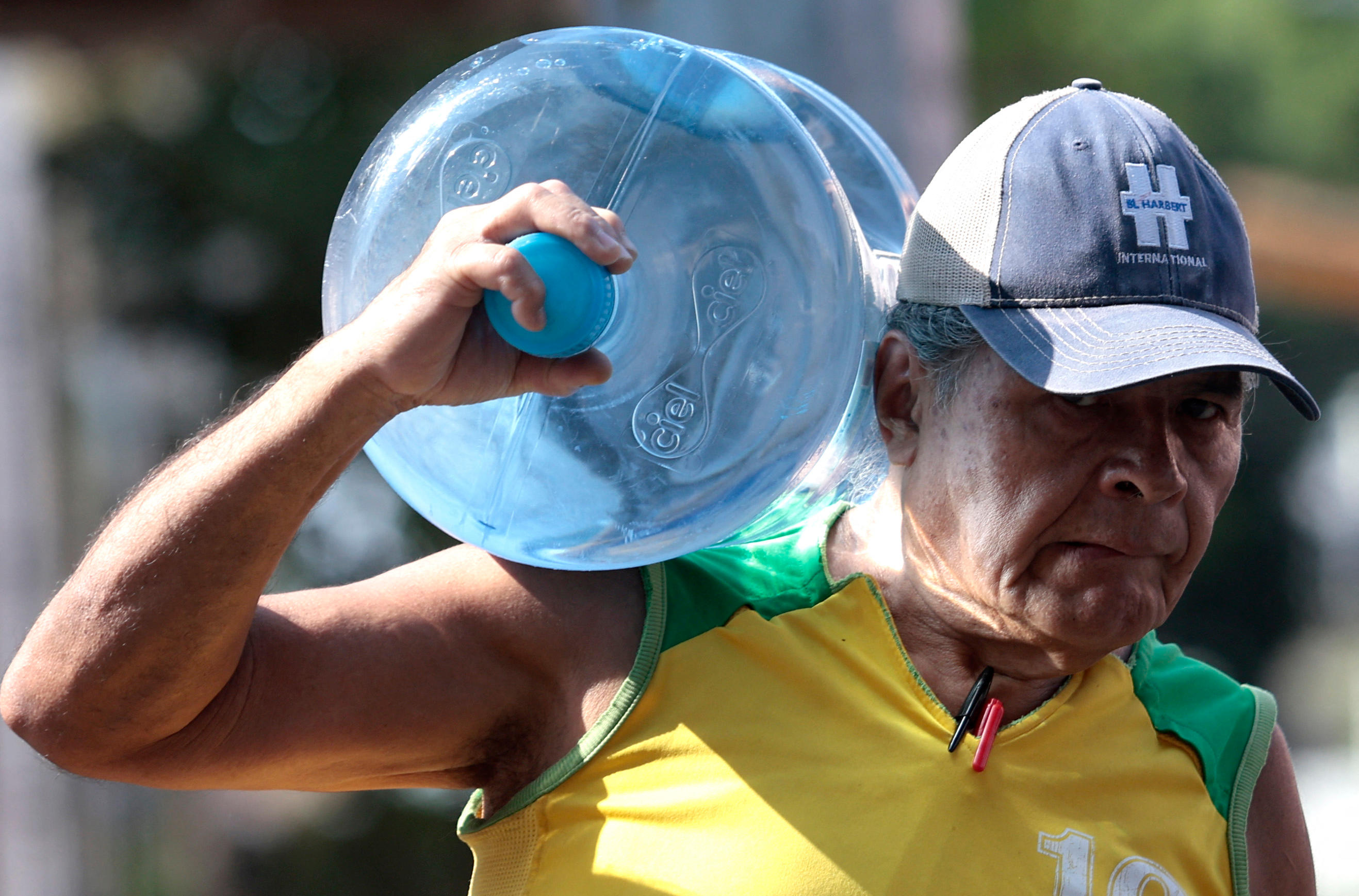 Guadalajara (Mexique), le 9 mai. Un homme transporte un important bidon d'eau. AFP/Ulises Ruiz