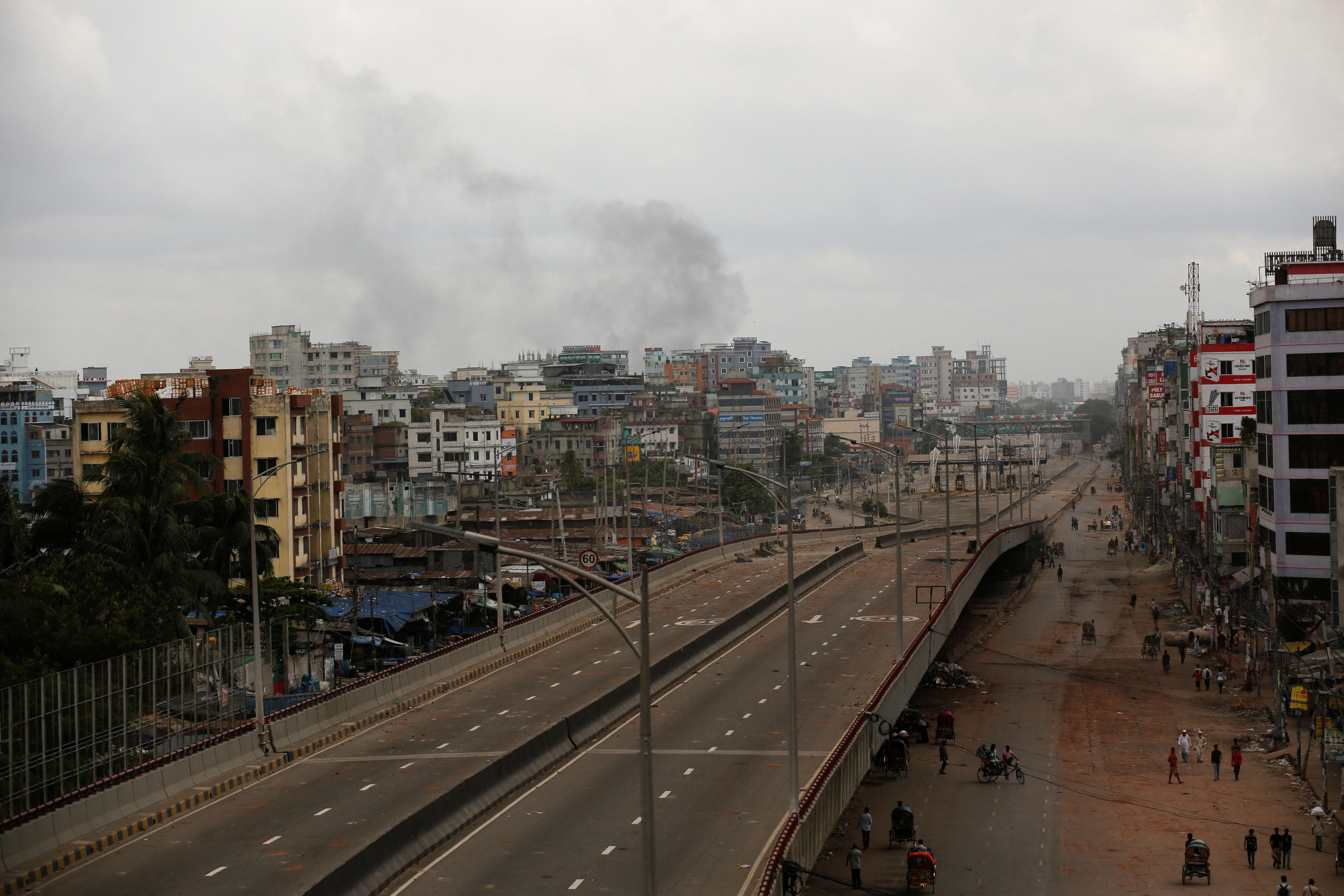 Malgré le couvre-feu, les manifestations continuent et une fumée noire s'élève ce dimanche du quartier de Shonir Akhra, à Dacca, la capitale du Bagnaldesh. REUTERS/Stringer