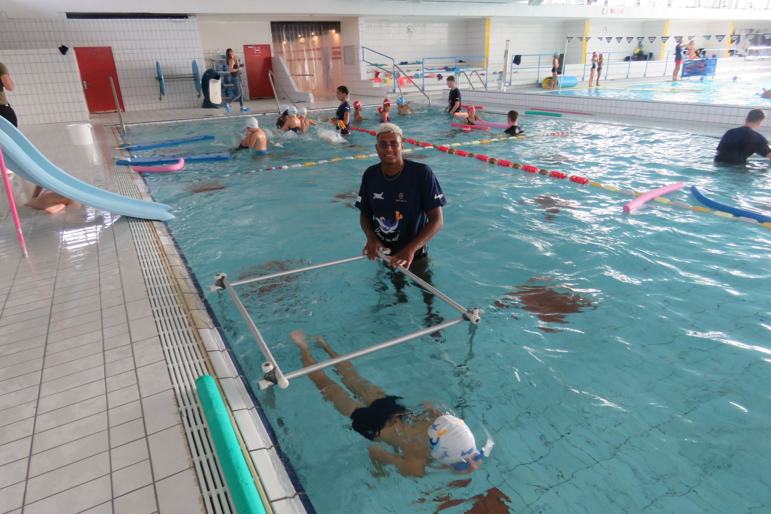 Melun, le 14 septembre 2022. Champion d'Europe 2022 du 200 mètres dos, Yohann Ndoye Brouard suit les enfants qui passent sous l'eau dans le petit bassin. LP/S.B.