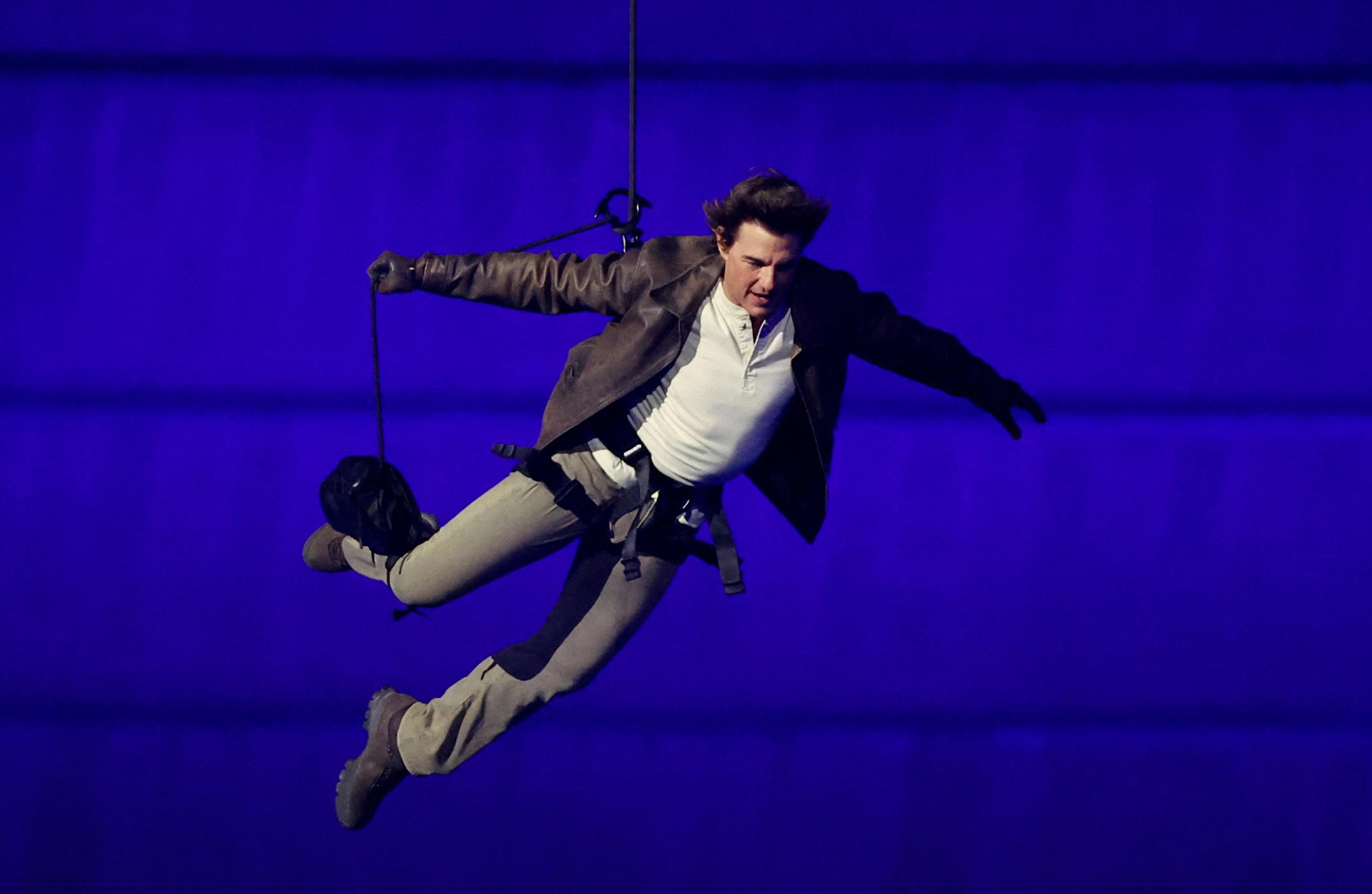 Tom Cruise, sur les toits du Stade de France avant sa descente en rappel. AFP/ Phil Noble