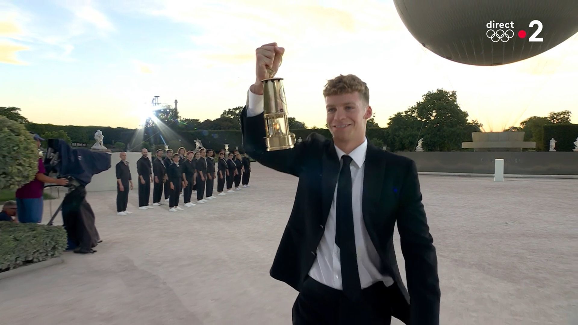 Tout sourire, Léon Marchand porte fièrement la flamme olympique, allumée en Grèce le 16 avril dernier. (Document  France Télévision)