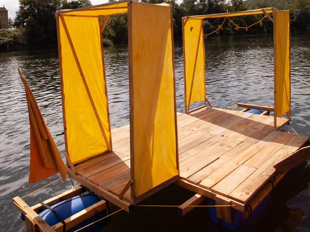 Le radeau, dont la construction a commencé le week-end dernier sur la plage de Saint-Cirq-Lapopie, est fabriqué avec des bidons et le plancher d’une précédente création artistique. DR