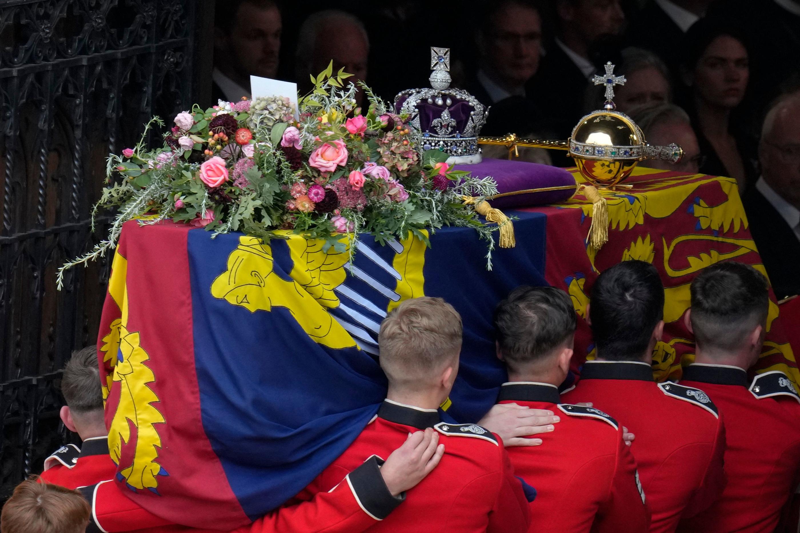 Les consultants présents sur les plateaux de télévision ont longtemps commenté le choix des fleurs ainsi que la signification des symboles (la bannière, la couronne, le sceptre et l'orbe) placés sur le cercueil d'Elizabeth II. AFP/Pool/Kirsty Wigglesworth