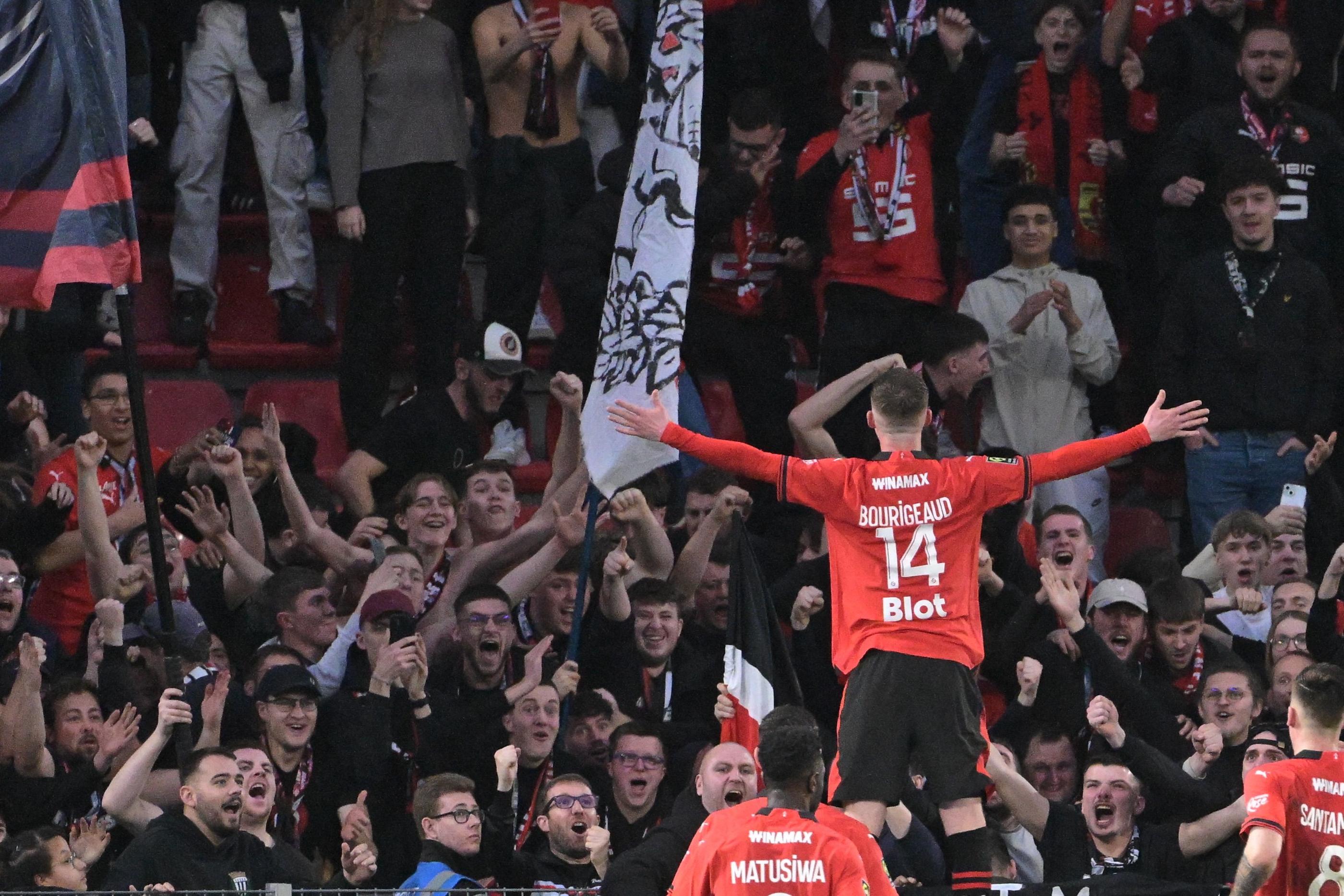 Benjamin Bourigeaud  célèbre son but avec les supporters de Rennes.(Photo by Damien Meyer / AFP)