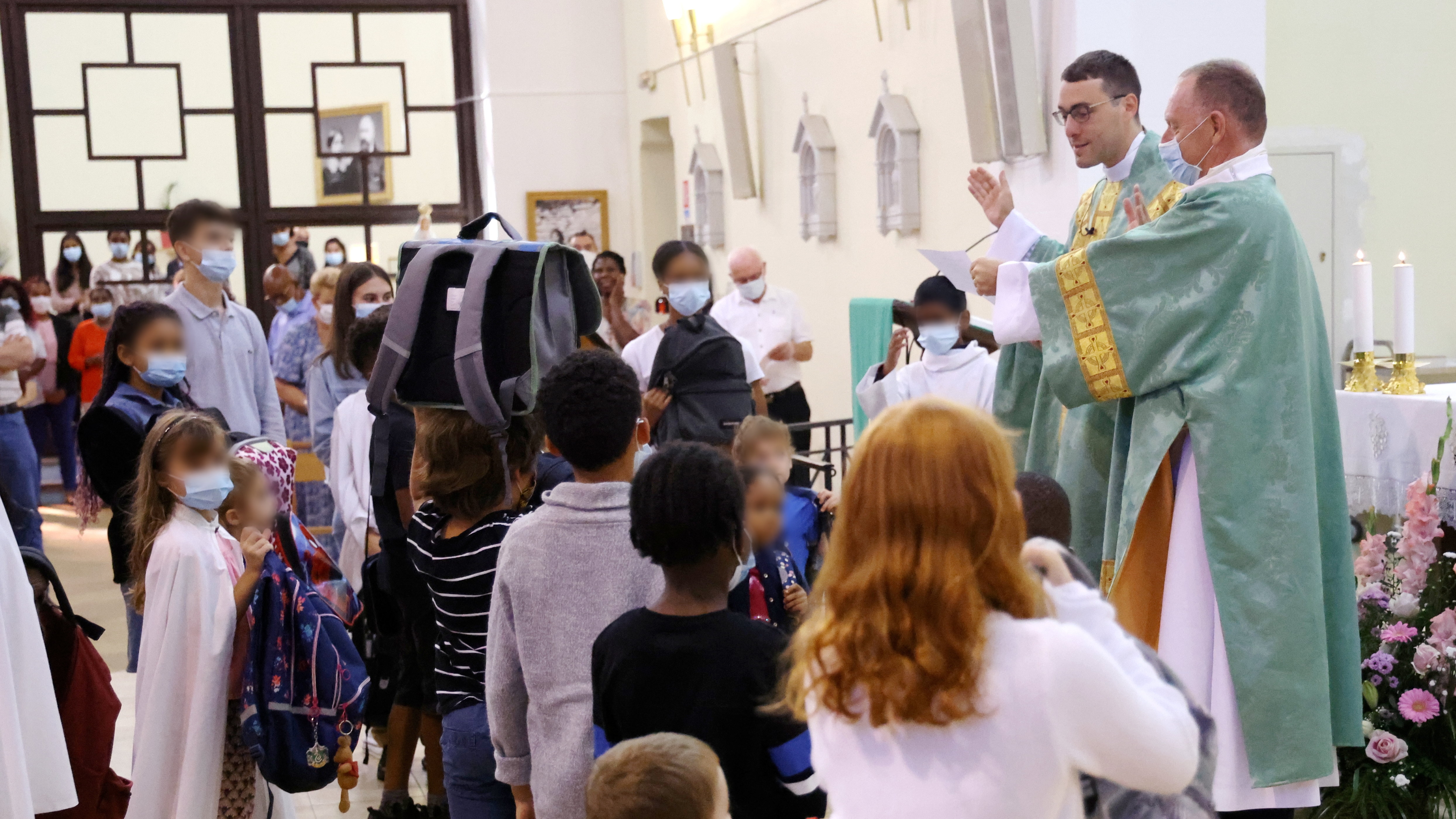 A Notre-Dame-de-Lourdes, église des Pavillons-sous-Bois, le père Jocelyn bénit les cartables portés à bout de bras par les jeunes élèves. LP/Jean-Baptiste Quentin
