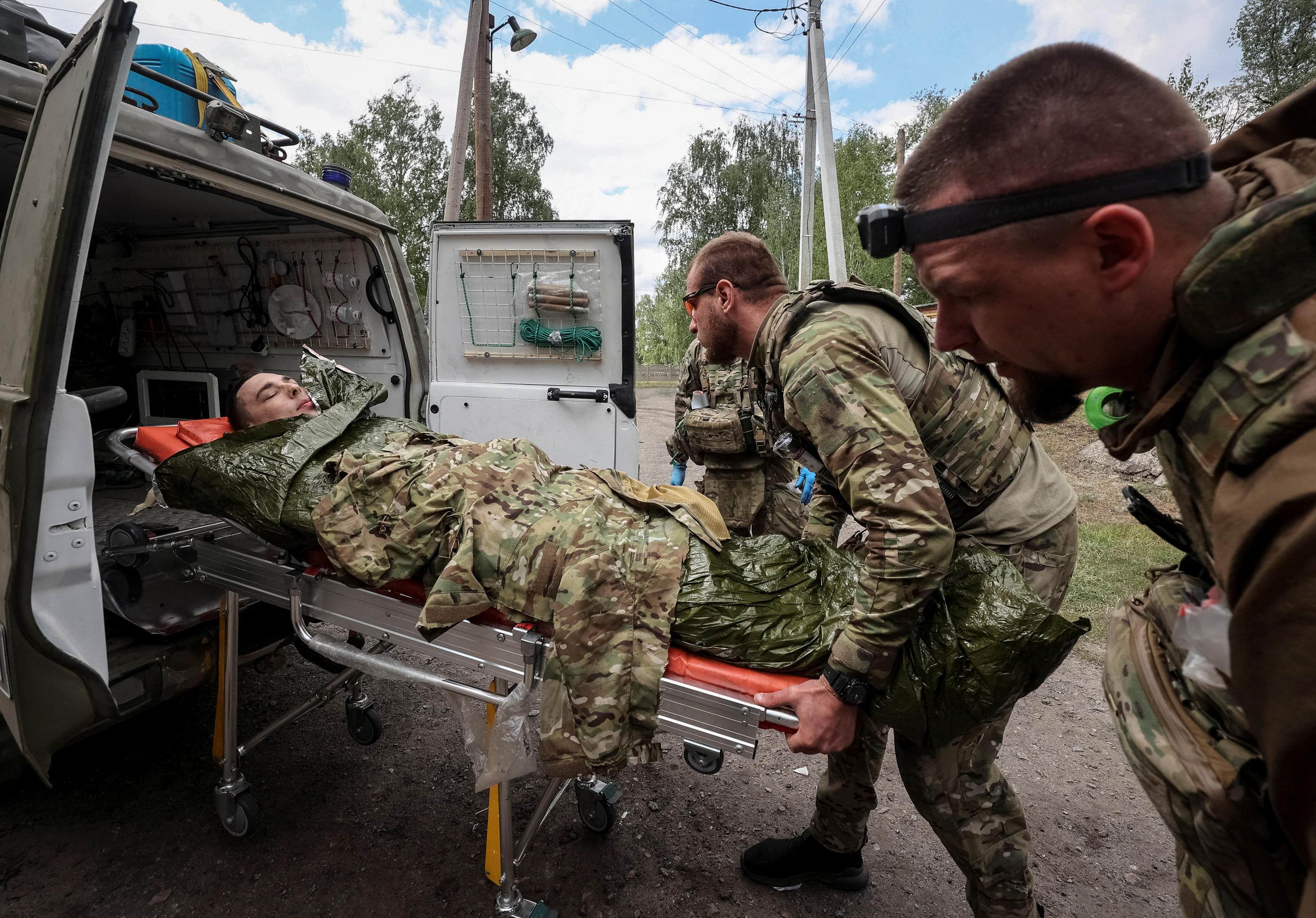 Des brancardiers de l'armée ukrainienne transportent un soldat blessé, dimanche dans la région de Kharkiv. REUTERS/Vyacheslav Madiyevskyy