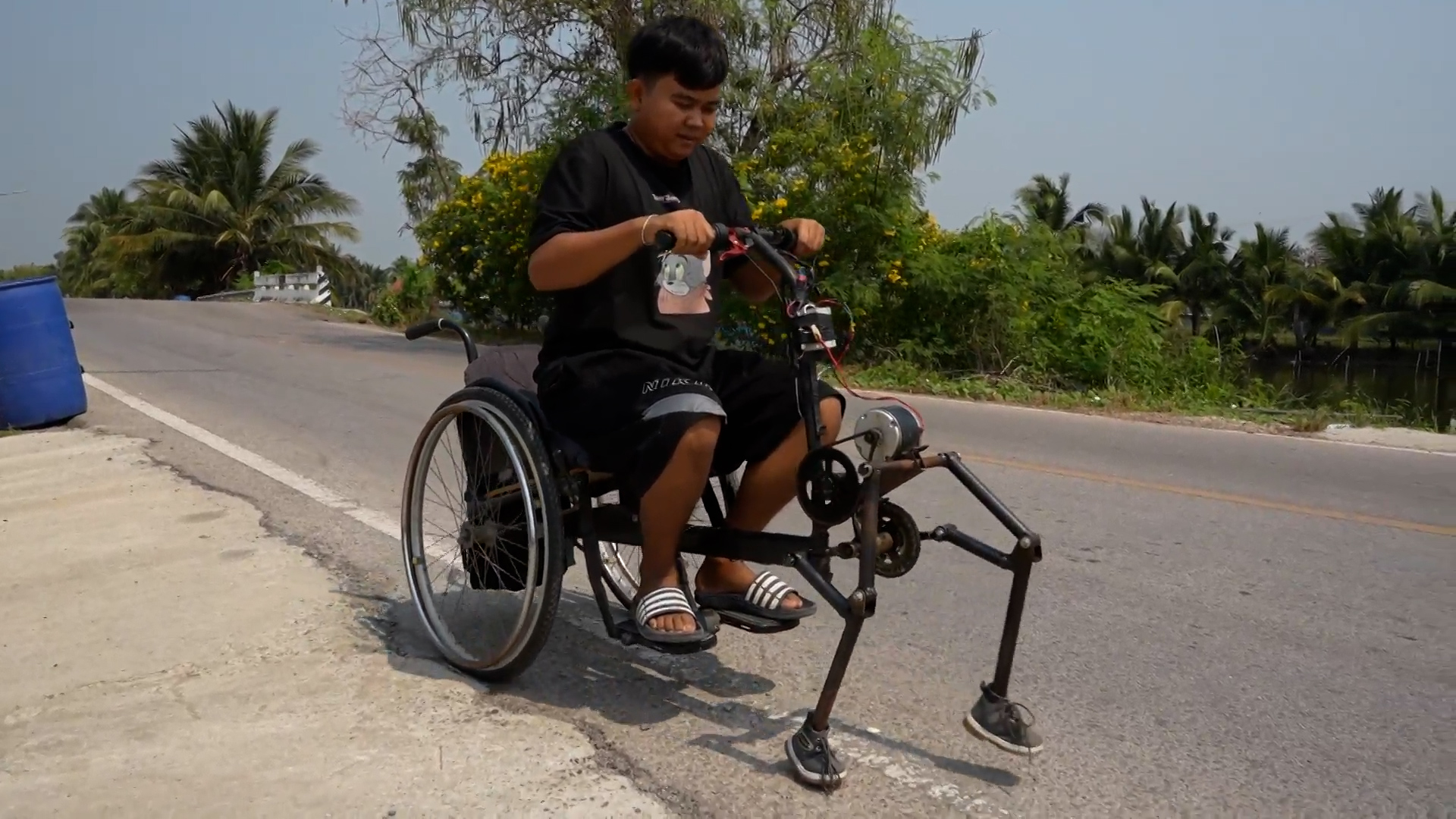 Un jeune thaïlandais a mis au point un fauteuil roulant tracté par des pieds pour circuler sur les routes abîmées.