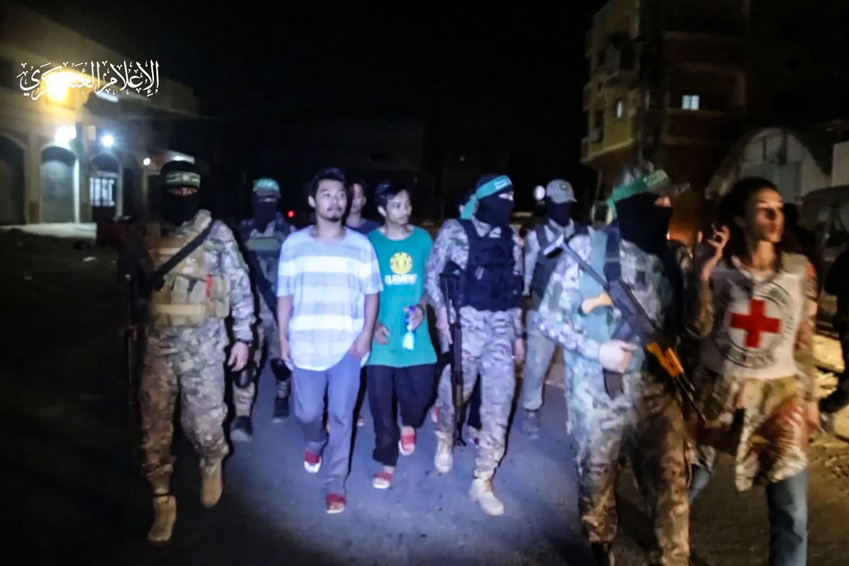 Cette capture d'une vidéo diffusée par le Hamas montre la remise d'otages thaïlandais remis dans la nuit de samedi à dimanche à la Croix Rouge. Via AFP