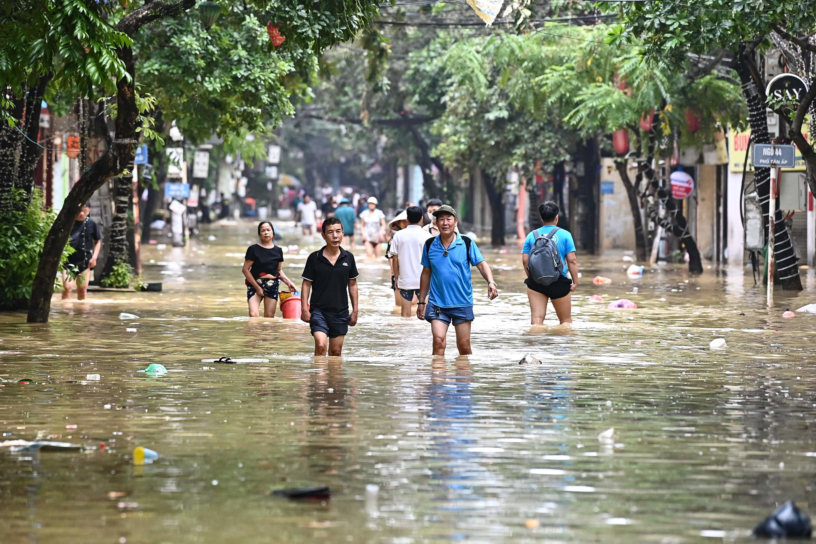 Hanoi (Vietnam), jeudi. Des personnes marchent dans un quartier inondé de la capitale. AFP/Nhac Nguyen