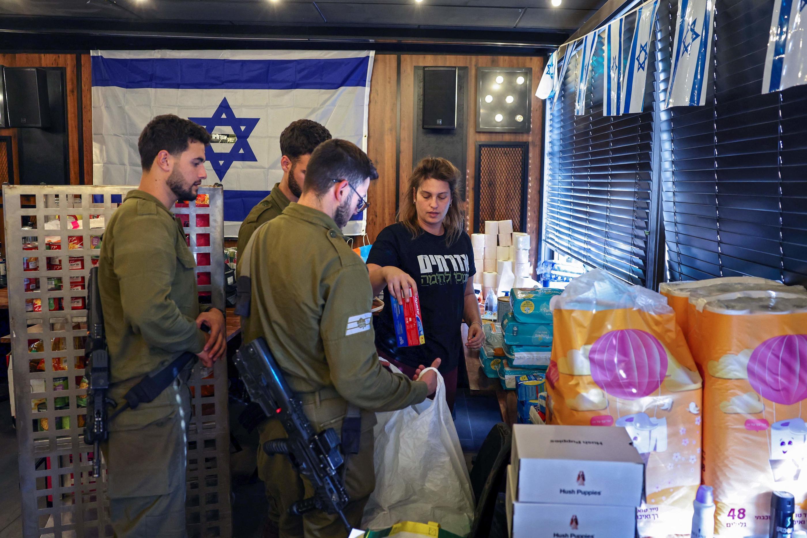 Nombre de volontaires se sont mobilisés, comme ici pour préparer des colis de produits essentiels à distribuer aux soldats isaraéliens, le 17 octobre à Ahskelon, dans le sud d'Israël. AFP/Thomas Coex