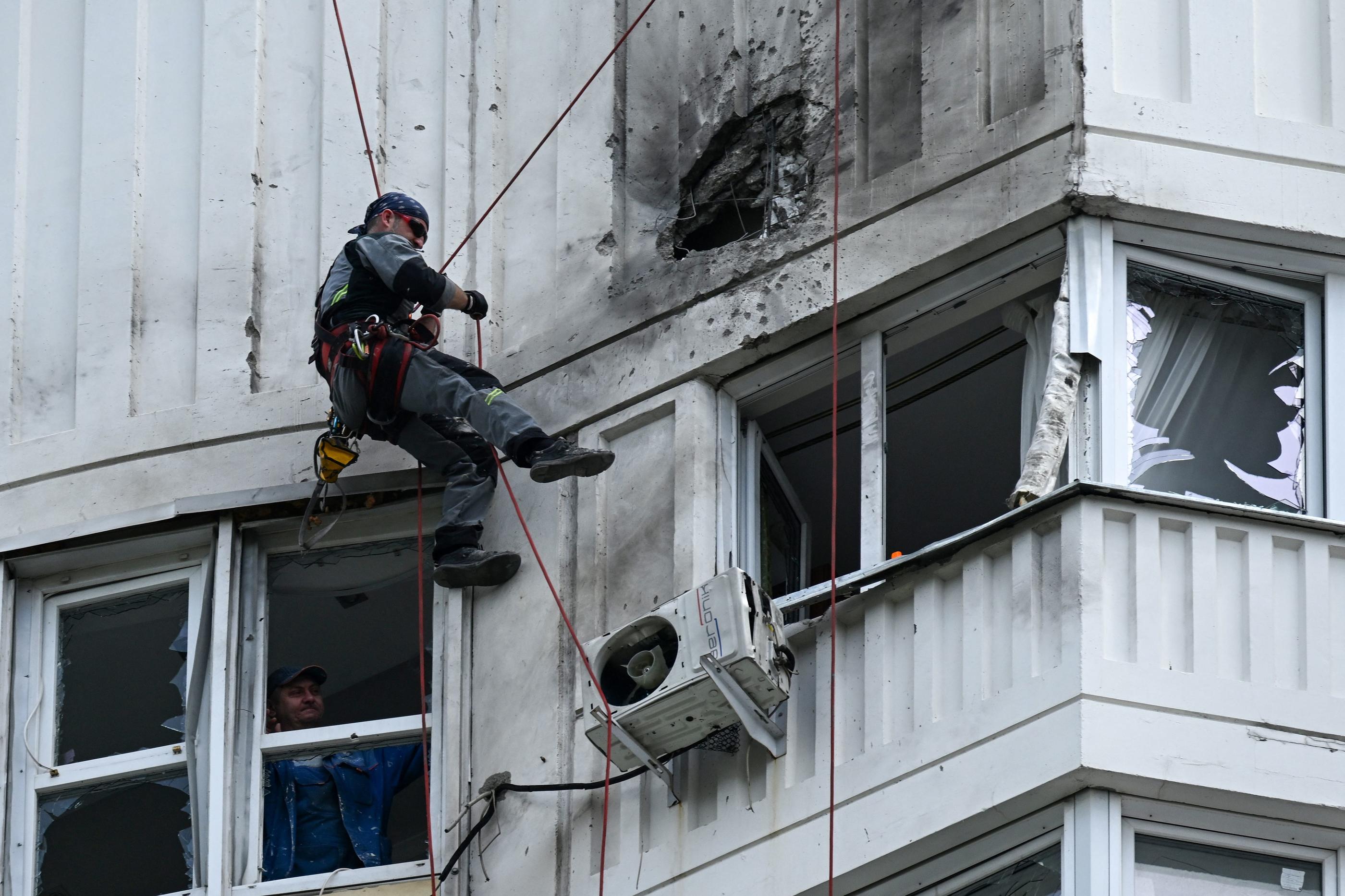 Un agent inspecte les dommages causés sur la façade d'un immeuble après les frappes de drones menées ce mardi, à Moscou, le 30 mai 2023. Kirill KUDRYAVTSEV / AFP