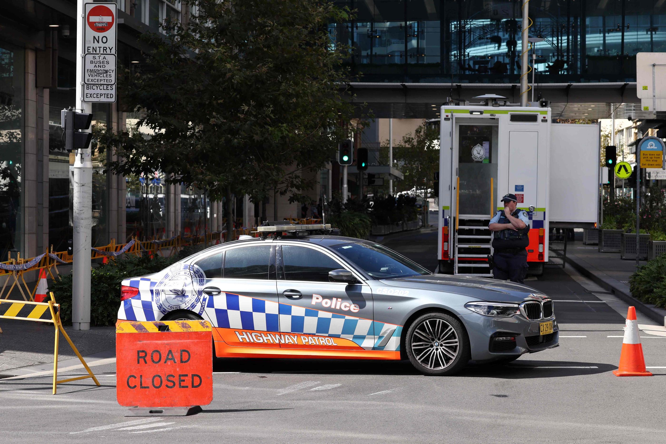 Un policier à l'extérieur du centre commercial Westfield Bondi Junction à Sydney (Australie), au lendemain de l'attaque au couteau qui a notamment coûté la vie à six personnes. AFP/David Gray