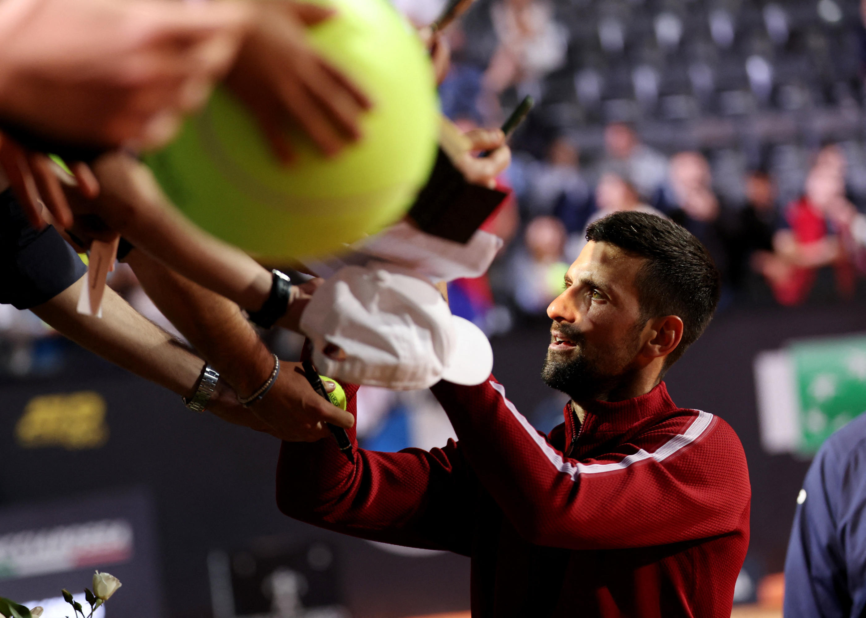 Quelques secondes après avoir signé des autographes, Novak Djokovic a reçu une gourde sur la tête (REUTERS/Claudia Greco)