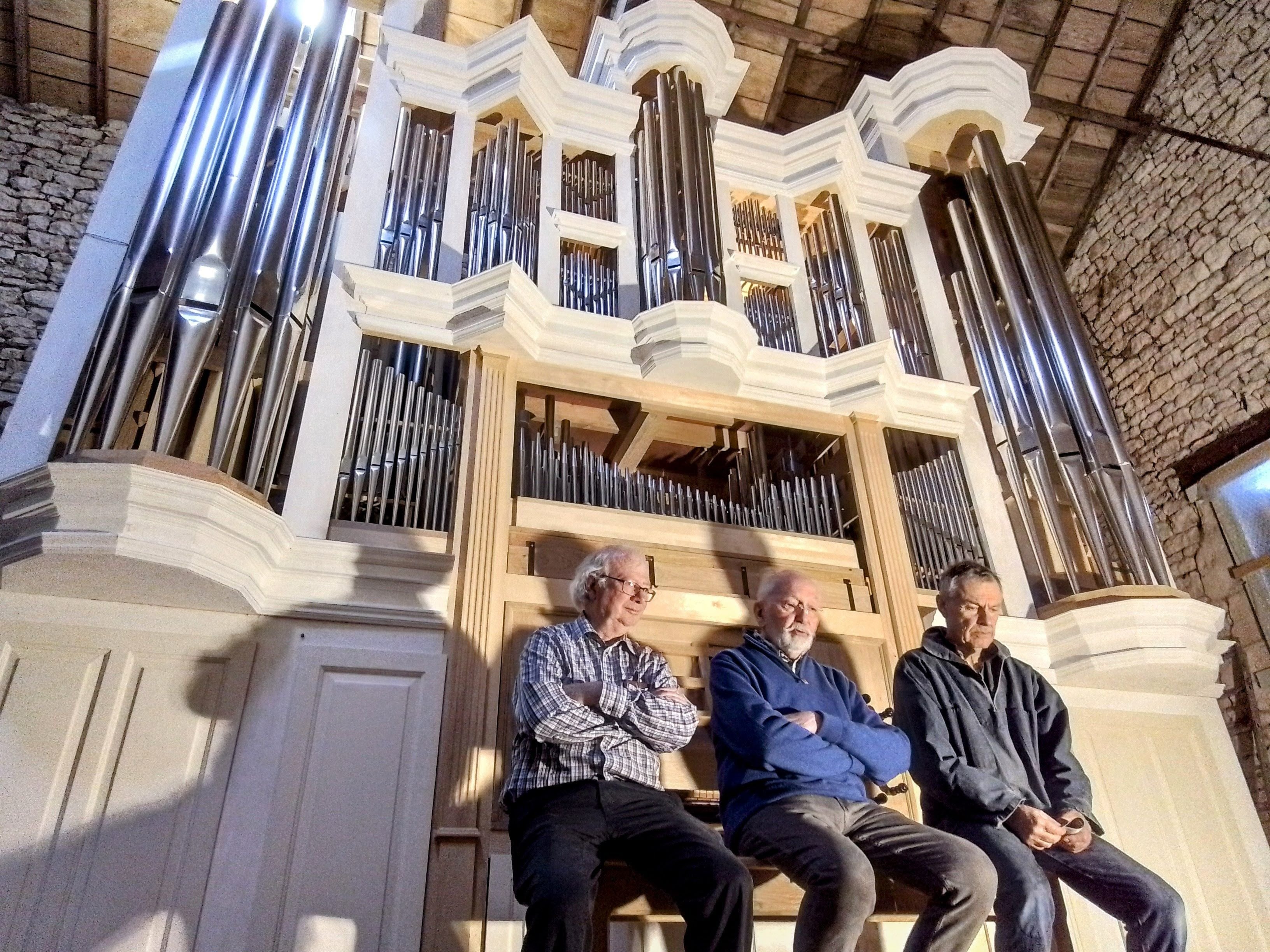René Peneau, président de l'association meldoise Valéran-de-Héman (au centre), est entouré de Jean-Marie Tricoteaux, l'harmoniste (à gauche) et de François Delhumeau, facteur d'orgues (à droite). Ils posent devant l'orgue, ici en Vendée, qui sera installé au musée Bossuet à Meaux. DR