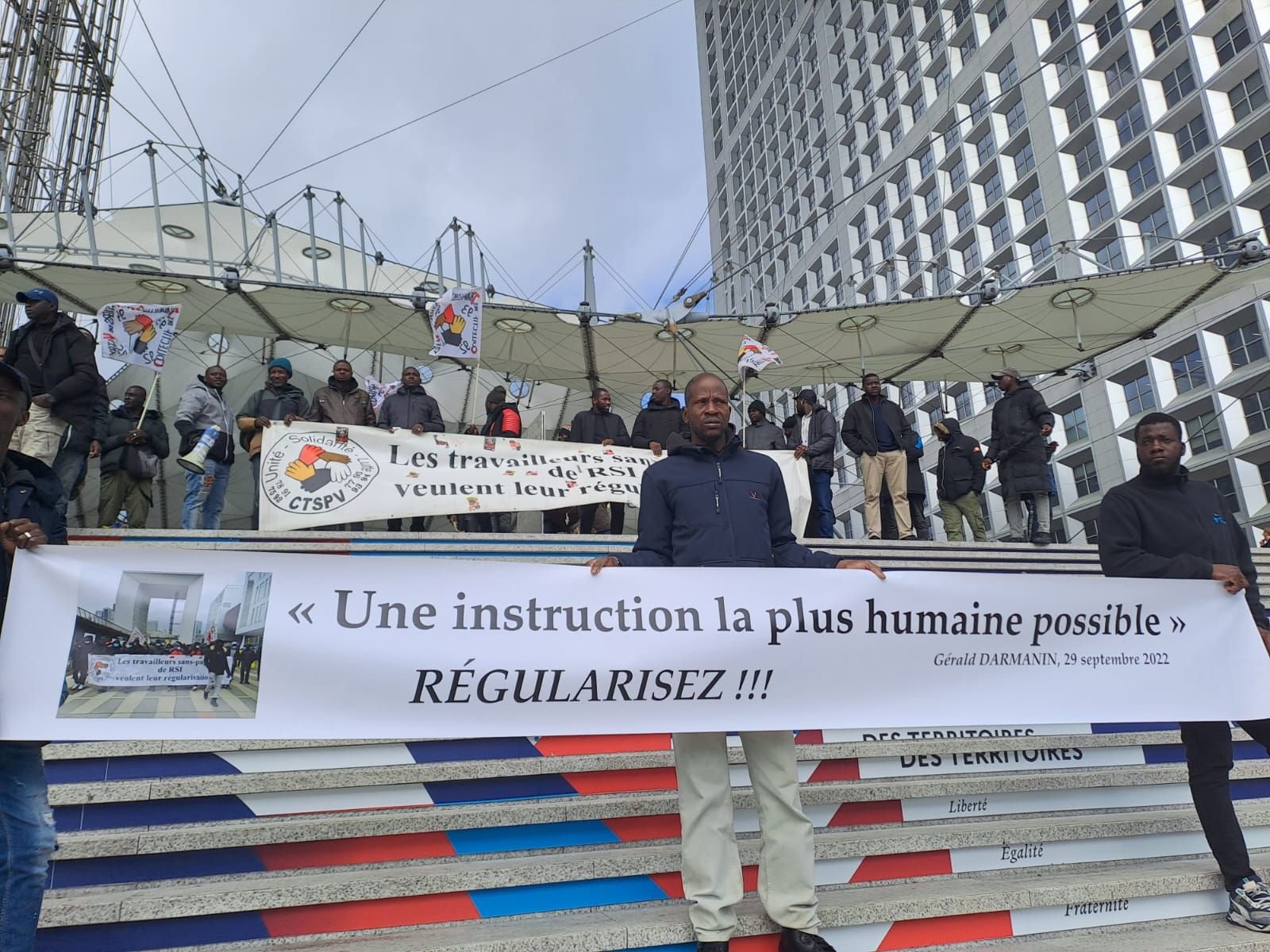 La Défense, le 4 avril. Six mois après leur dernière manifestation, les salariés sans-papier de RSI se sont rassemblés sur les marches de la Grande Arche. DR