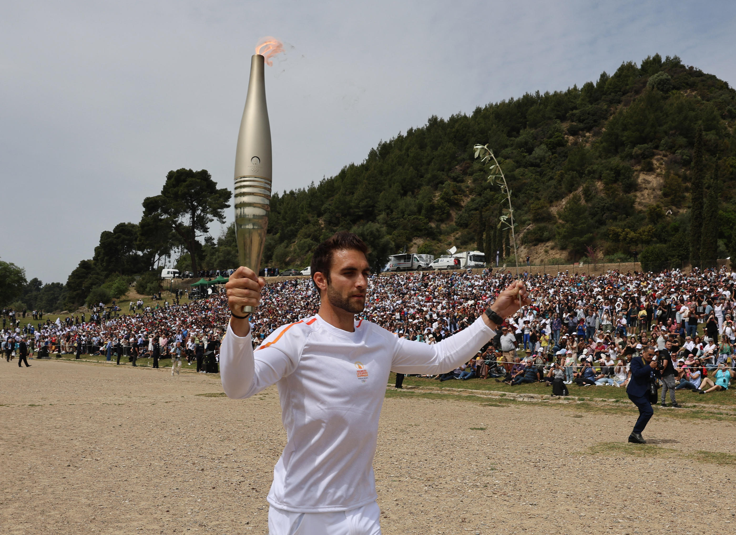 Le rameur grec Stefanos Ntouskos, champion olympique à Tokyo, a été le premier des relayeurs de la flamme olympique des Jeux de Paris ce mardi à Olympie. Reuters/Louisa Gouliamaki