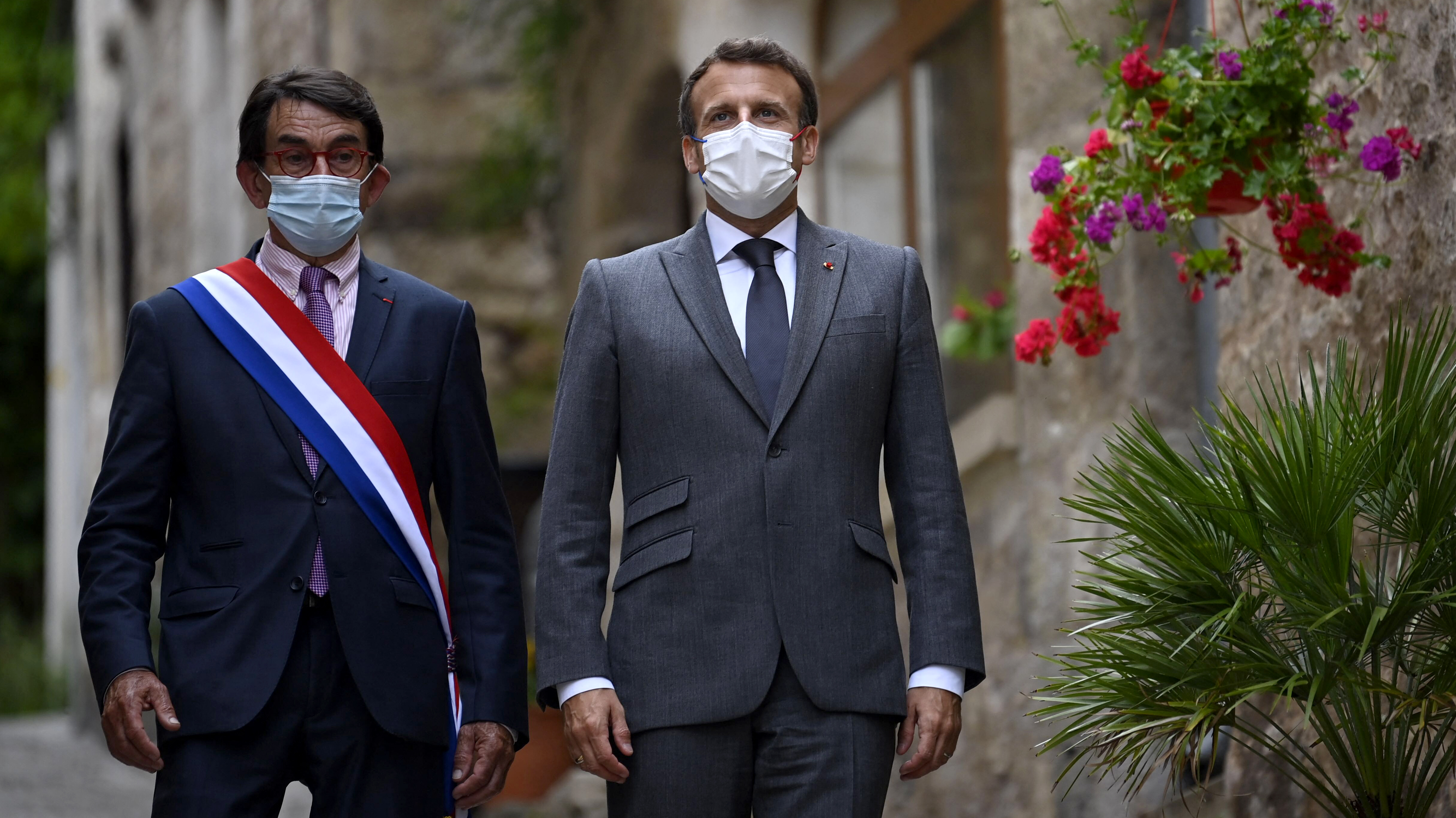 Le président Emmanuel Macron et le maire de Saint-Cirq-Lapopie Gérard Miquel marchent dans les rues du village, près de Cahors, le 2 juin 2021.