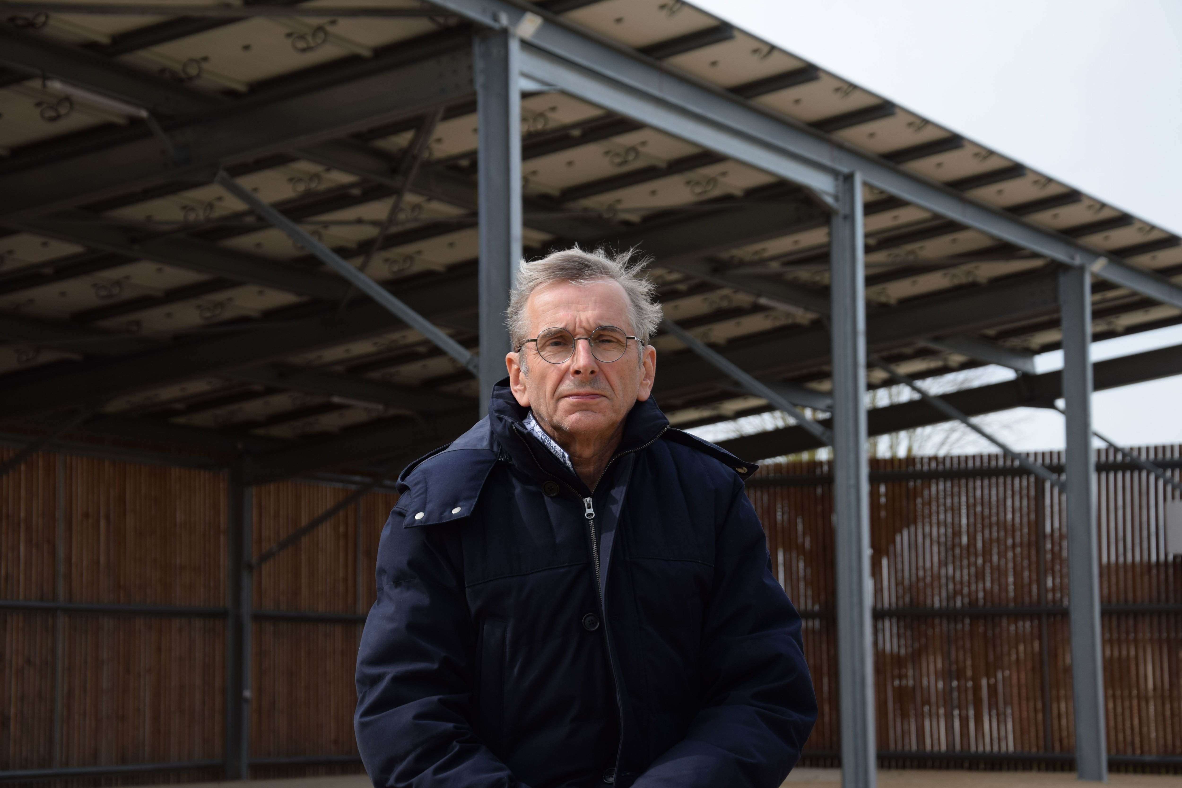 Le maire de Vieuvicq (Eure-et-Loir), Philippe Morelle, pose devant l'ombrière dotée de 253 modules photovoltaïques qui produit l’équivalent de la consommation de 50 habitants. LP/Christophe Blondel