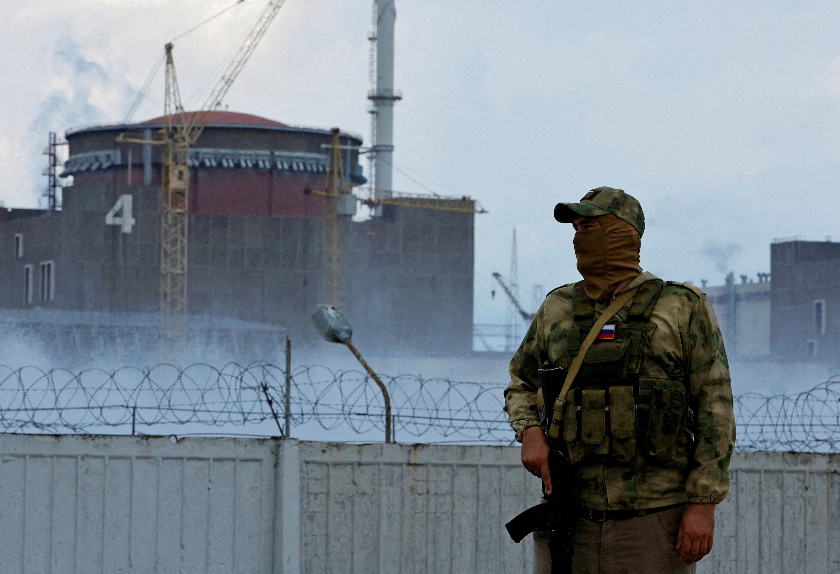 Enerhodar (Ukraine), le 4 août 2022. Un homme avec un écusson russe monte la garde aux abords de la centrale nucléaire de Zaporijjia. Reuters/Alexander Ermochenko