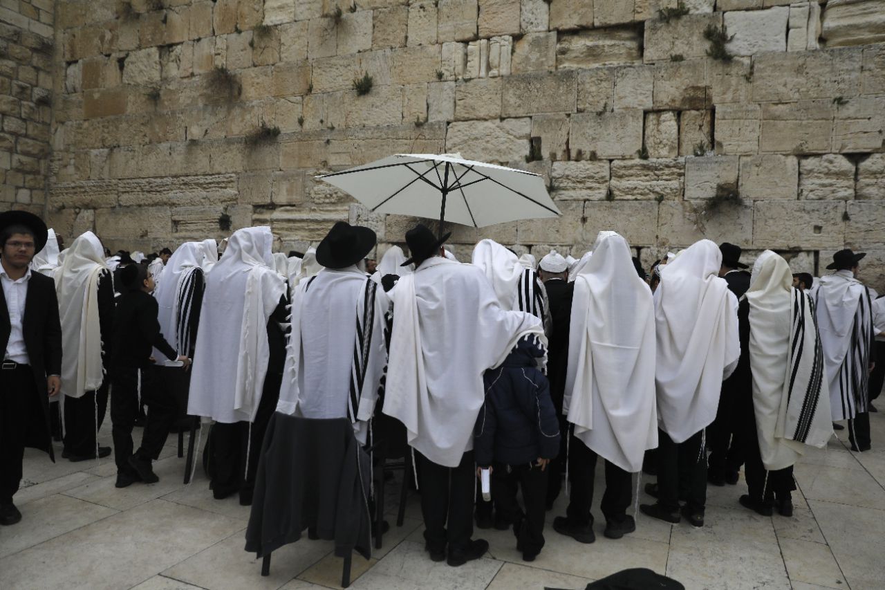 Un groupe d'hommes juifs portant le traditionnel châle Talit, le 13 avril 2017, à Jérusalem pour la fête de Pessah (illustration). AFP/MENAHEM KAHANA