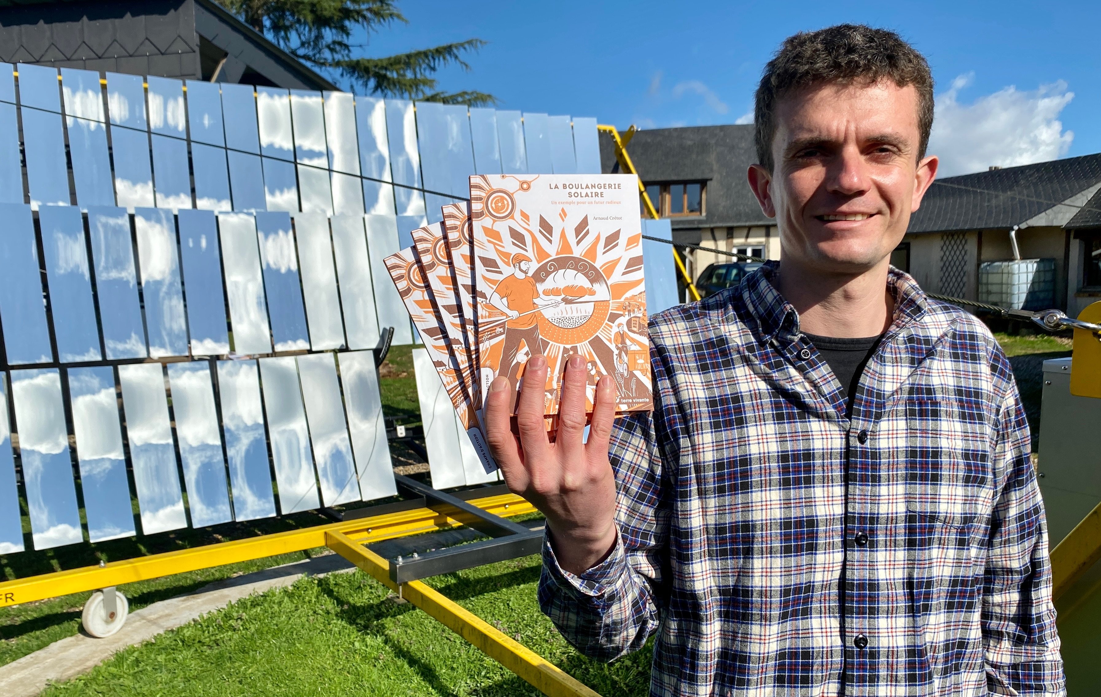 Devant les miroirs de son four à concentration solaire, Arnaud Crétot présente le livre qu'il vient de publier aux éditions Terre vivante. LP/Laurent Derouet
