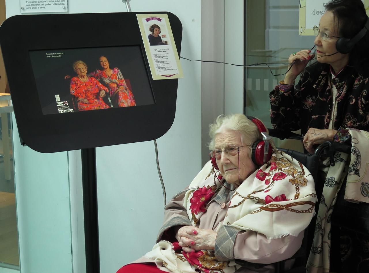 <b></b> Issy-les-Moulineaux, samedi 4 novembre 2017. Alice, 102 ans (au centre) et sa fille Eliane, 78 ans (à droite) découvrent l’exposition dont elles ont participé à la création pendant de longs mois en racontant leurs souvenirs d’enfance.