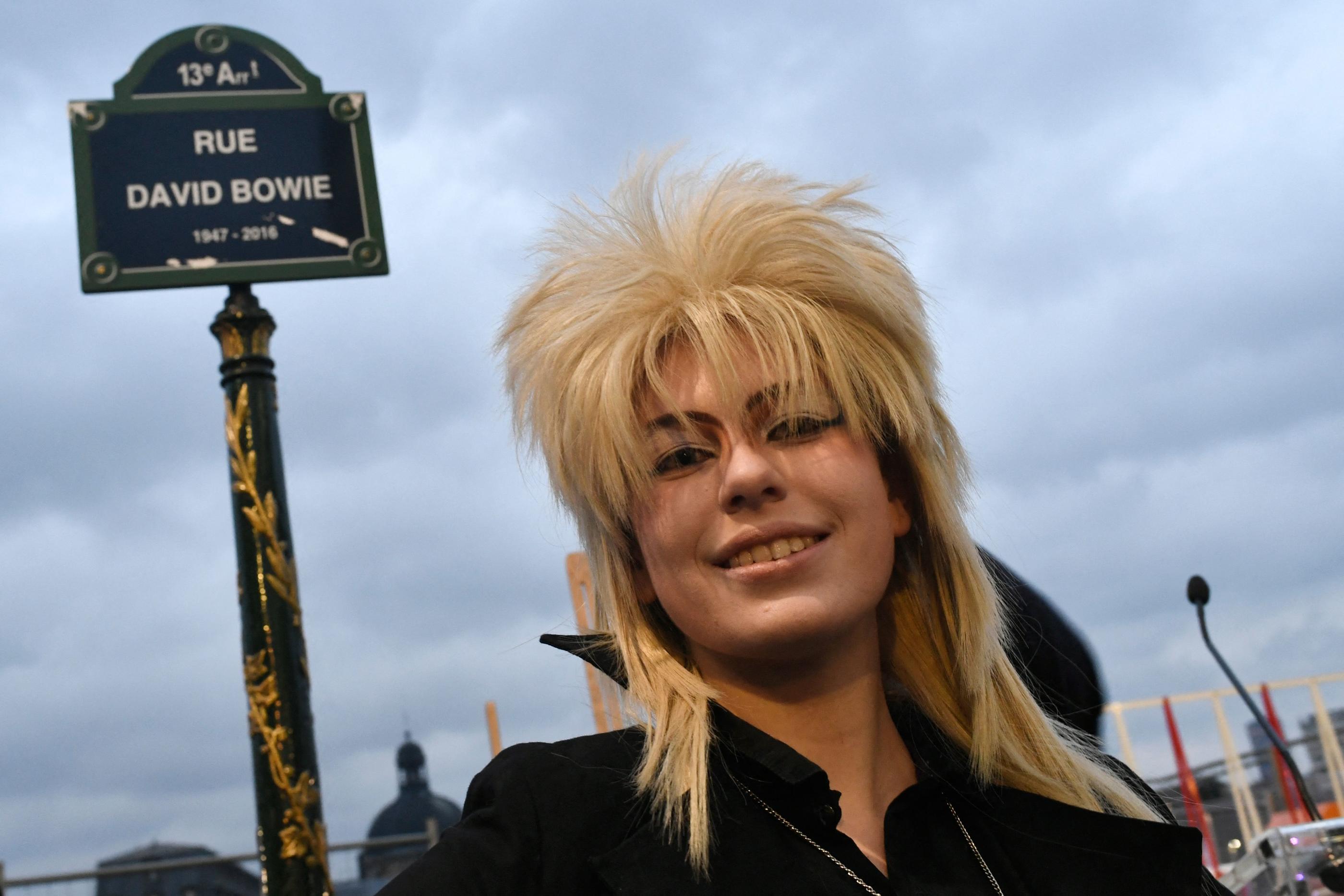 Paris (XIIIe), ce lundi. Une femme pose, coiffée d'une perruque hommage à David Bowie, dans la rue tout juste inaugurée à son nom. AFP/Stéphane de Sakutin