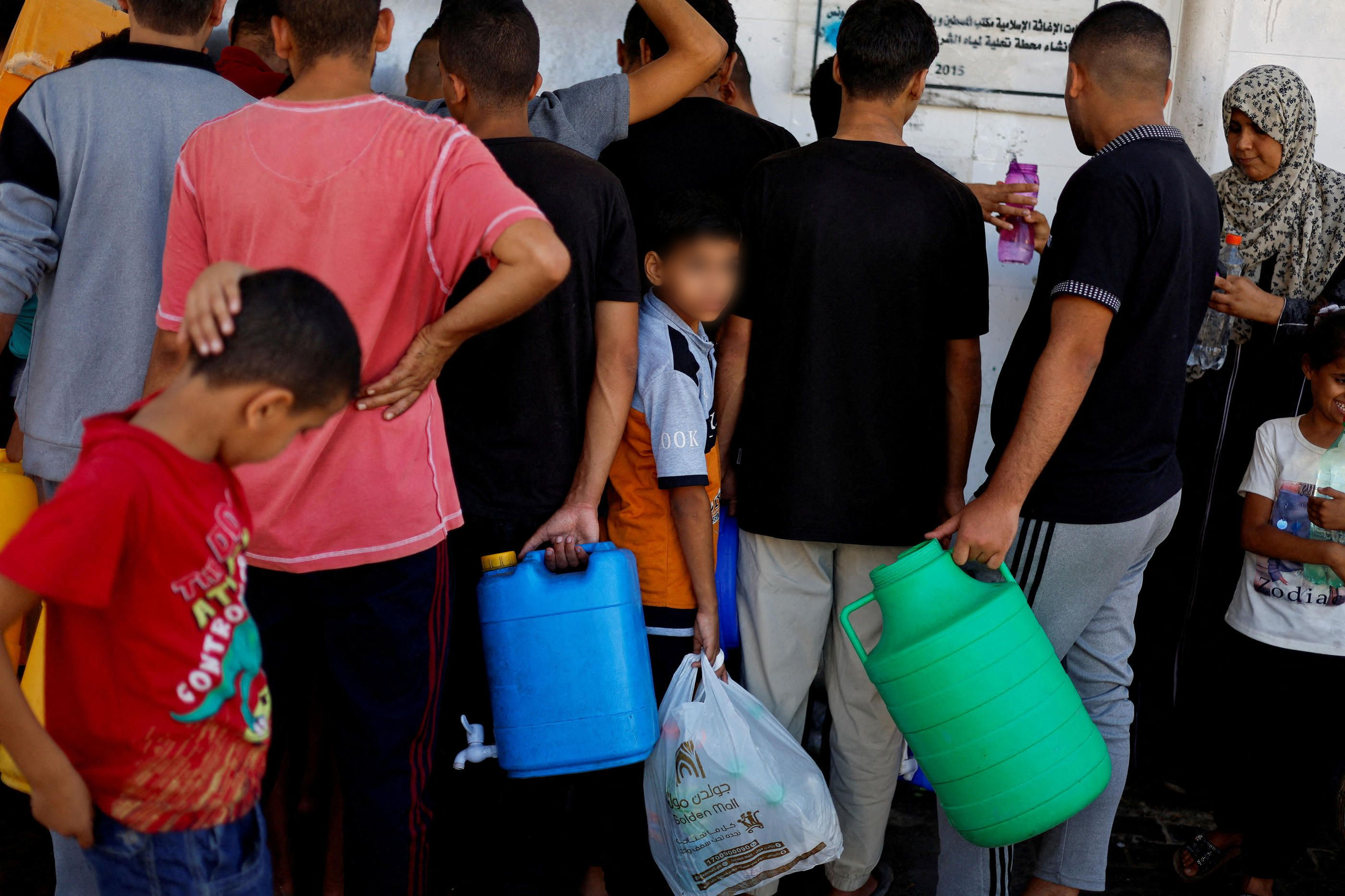 Khan Younès, sud de la bande de Gaza, le 15 octobre 2023. Des Palestiniens font la queue pour récupérer le peu d'eau potable qu'il reste. Cette ville, qui abrite normalement 400 000 habitants, accueille désormais plus d'un million de personnes. REUTERS/Mohammed Salem