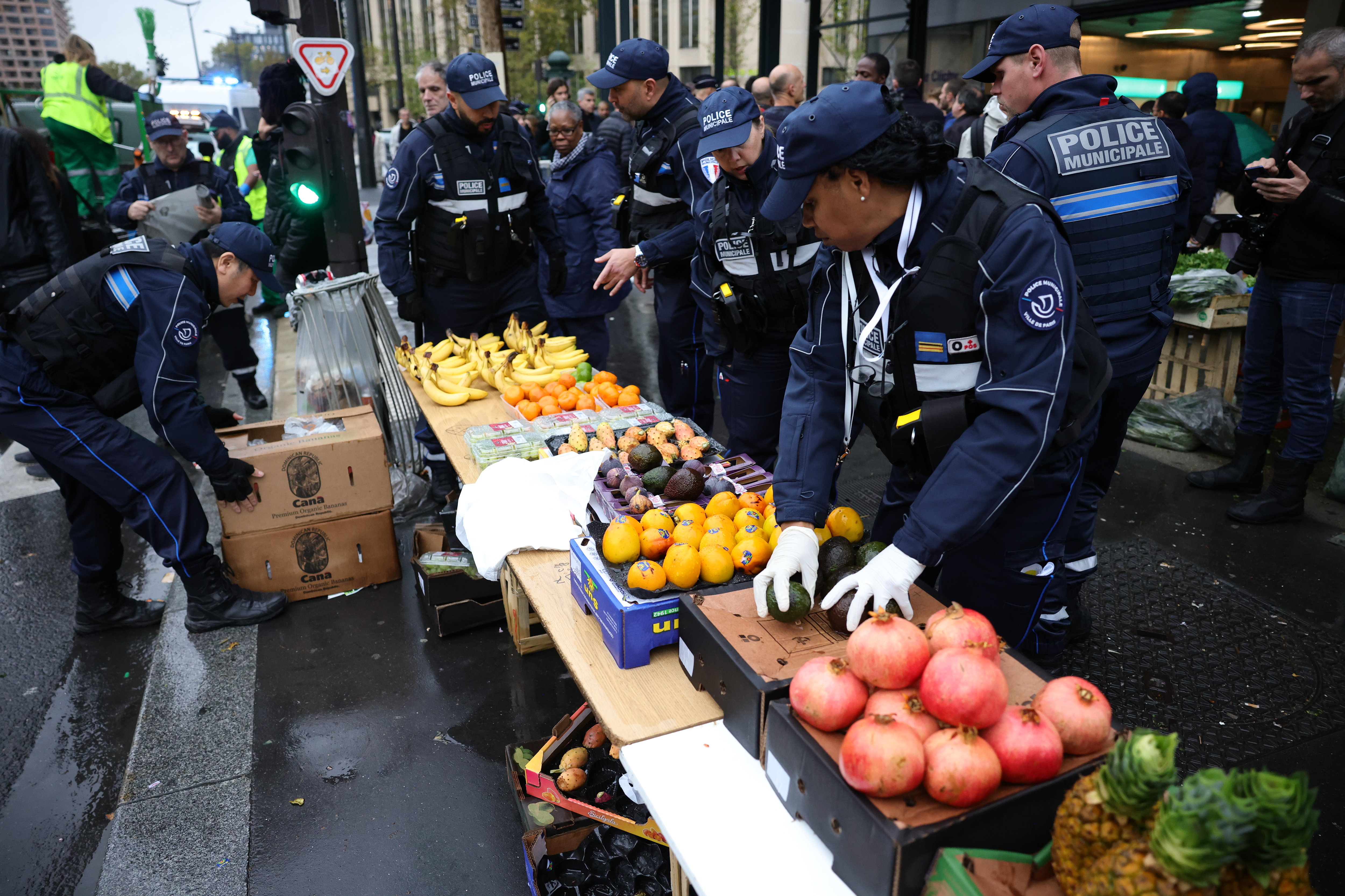Paris (XVIIe), ce mercredi.  Des policiers saisissent les étals de fruits et légumes des vendeurs à la sauvette. LP/Olivier Arandel
