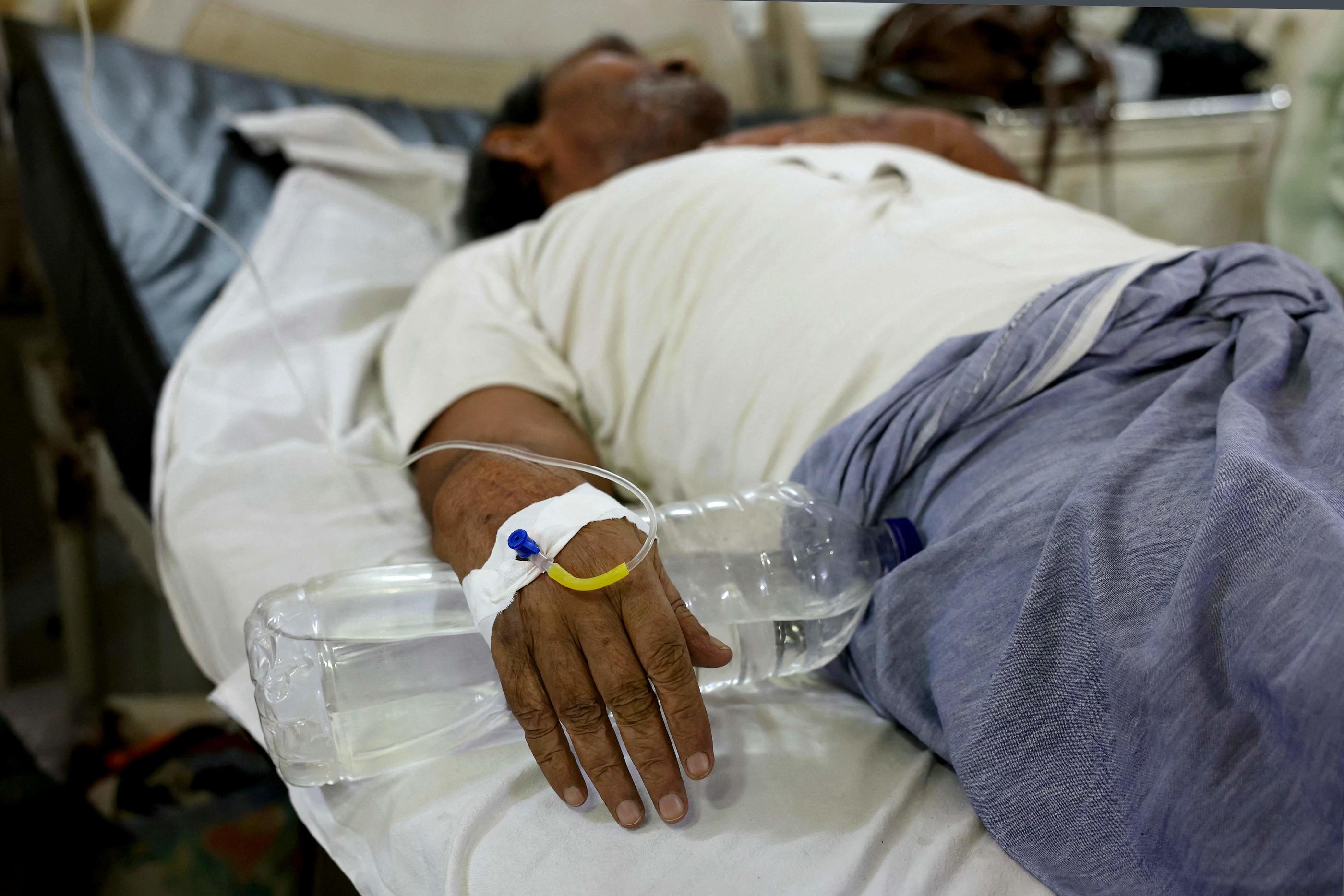 Un patient souffrant d'épuisement dû à la chaleur reçoit une solution saline par perfusion intraveineuse dans une salle d'urgence d'un hôpital gouvernemental à Varanasi. AFP/Niharika KULKARNI.