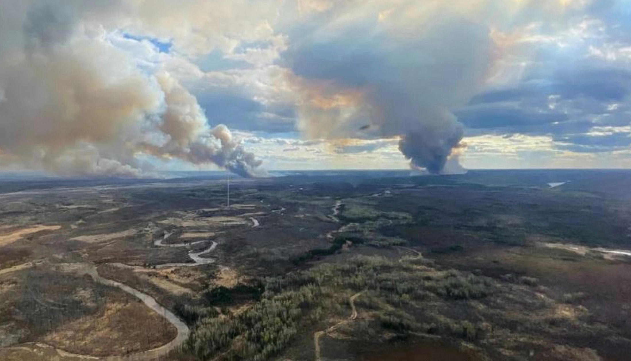 Des colonnes de fumée dans la zone forestière de Fort McMurray dans l'Alberta, le 13 mai. AFP/Photo transmise par l'Alberta Wildfire