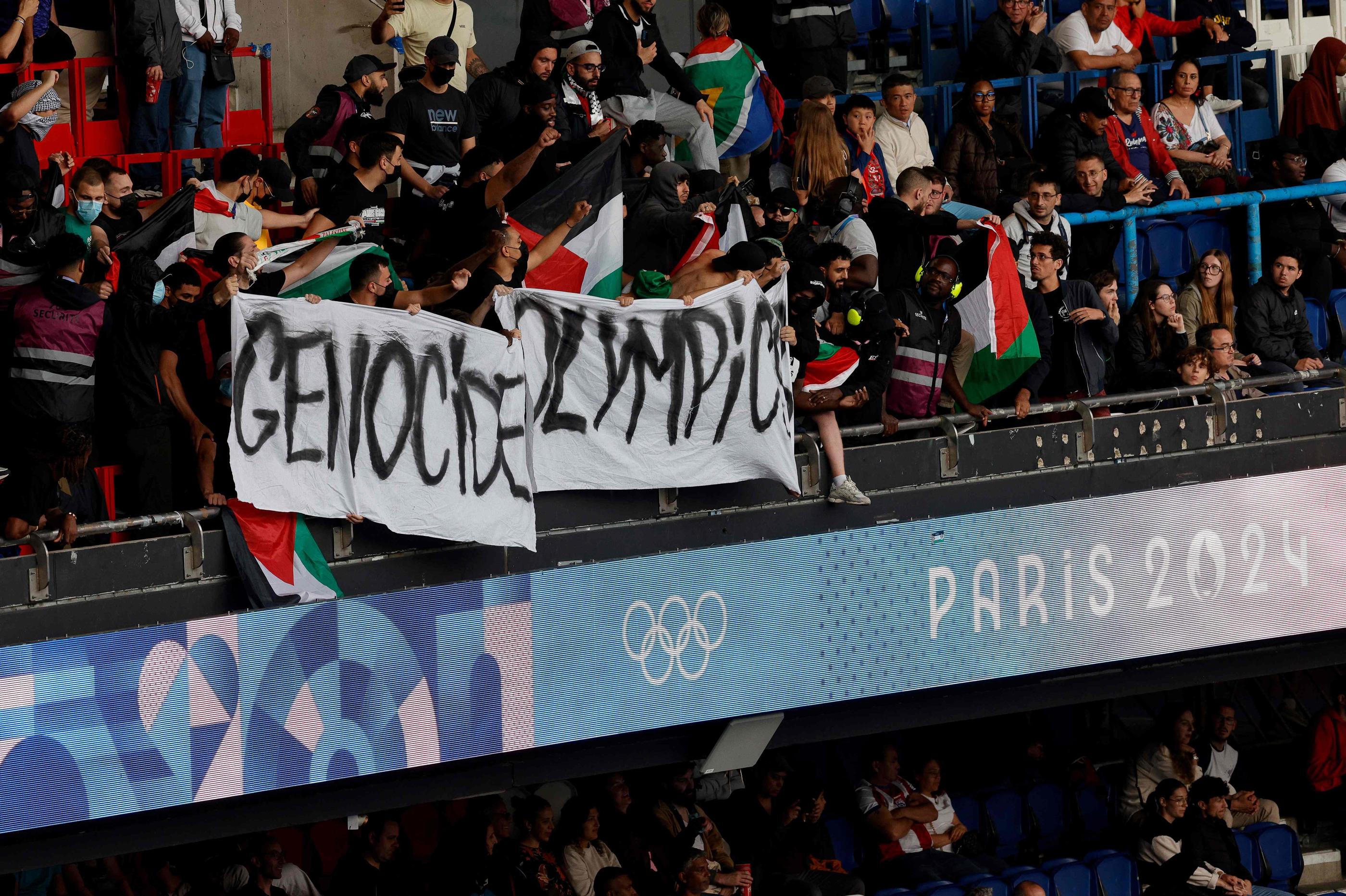 Une banderole "Genocide Olympic" a été déployée pendant le match Israël-Paraguay. GEOFFROY VAN DER HASSELT/AFP