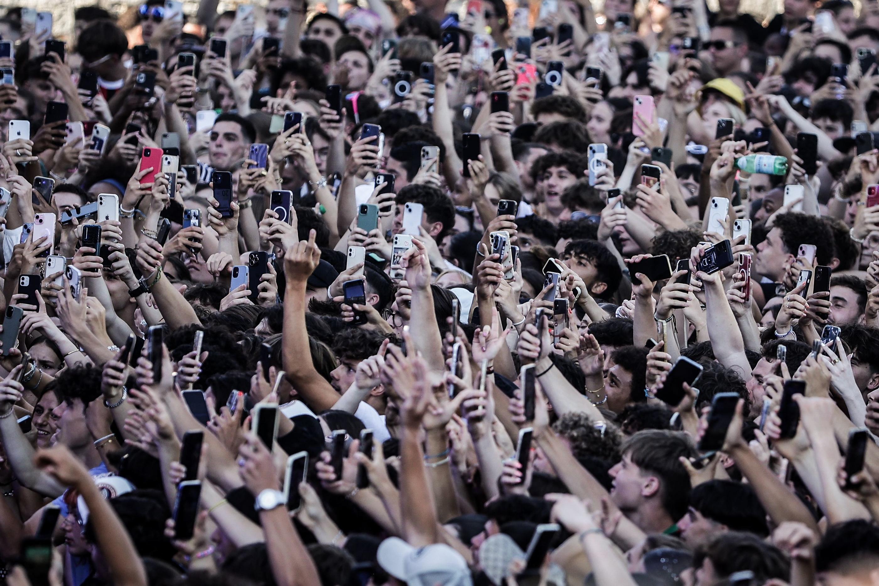 Face à la grande scène où vont se produire Bigflo et Oli, c’est la fête pour le public qui dégaine une nuée de téléphones. AFP/Thibaud Moritz