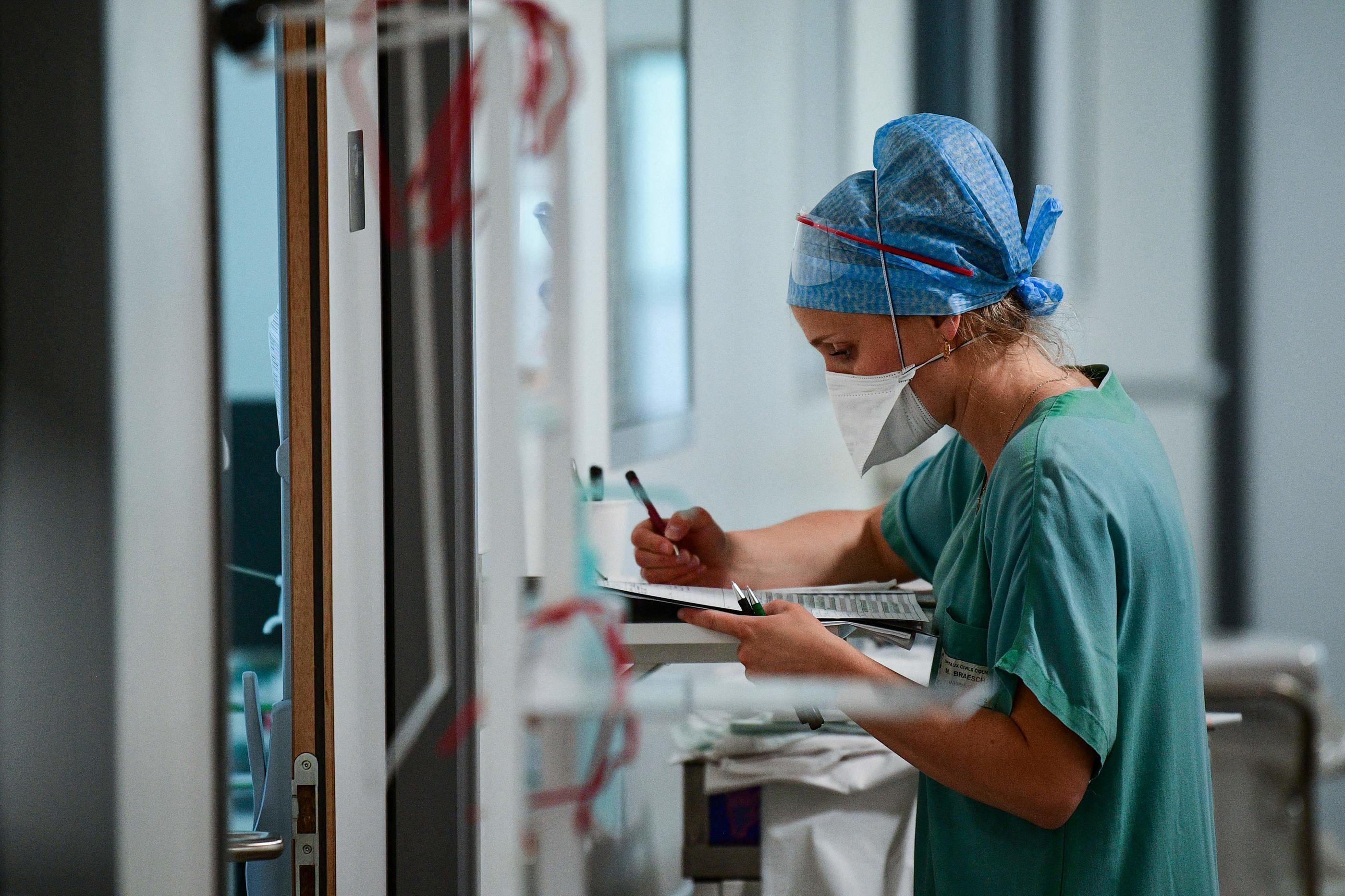 Une soignante remplit le dossier d'un patient atteint du Covid-19 à l'hôpital Pasteur de Colmar. AFP/Sebastien Bozon