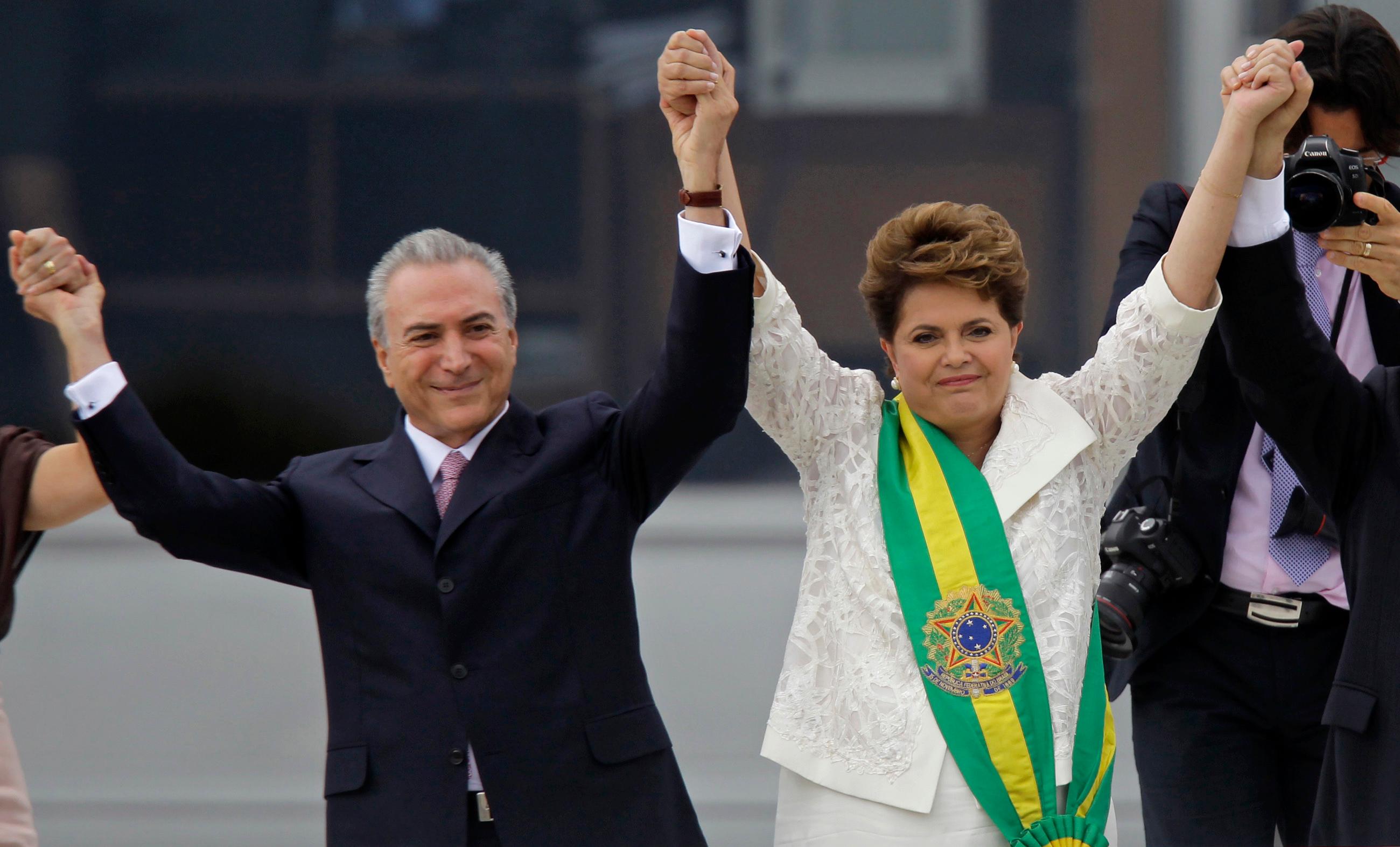 FILE - In this Jan. 1, 2011 file photo, Brazil's President Dilma Rousseff, right, raises arms with her Vice President Michel Temer at the end of her swearing-in ceremony at Planalto Palace in Brasilia, Brazil. Temer surprised Brazilians on Monday, Sept. 16, 2019 by referring to the 2016 impeachment of Rousseff as a coup for the first time. (AP Photo/Silvia Izquierdo, File)