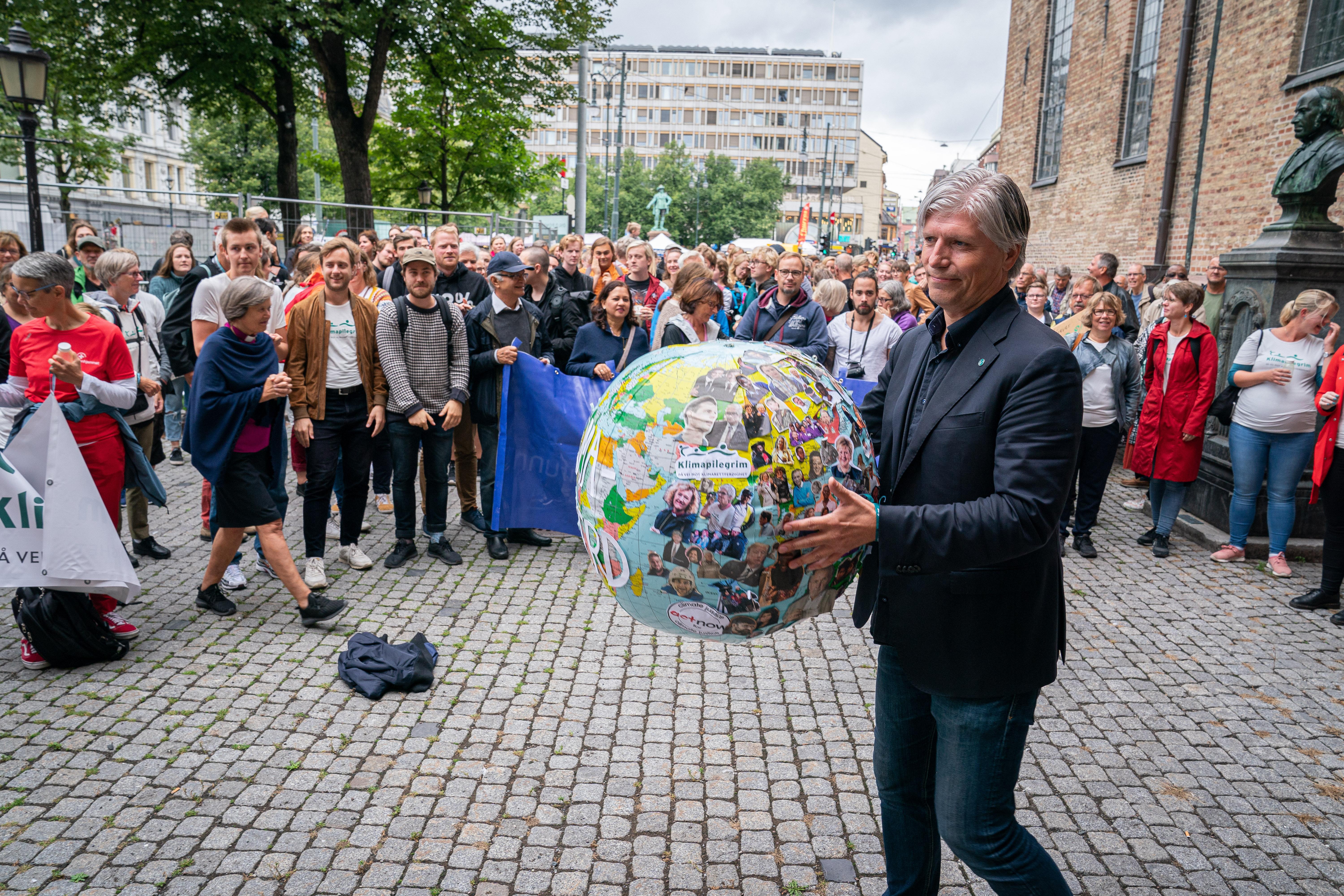 Ola Elvestuen får overlevert klimakrav. Klimapilegrim på Klimabrølet foran Oslo domkirke.