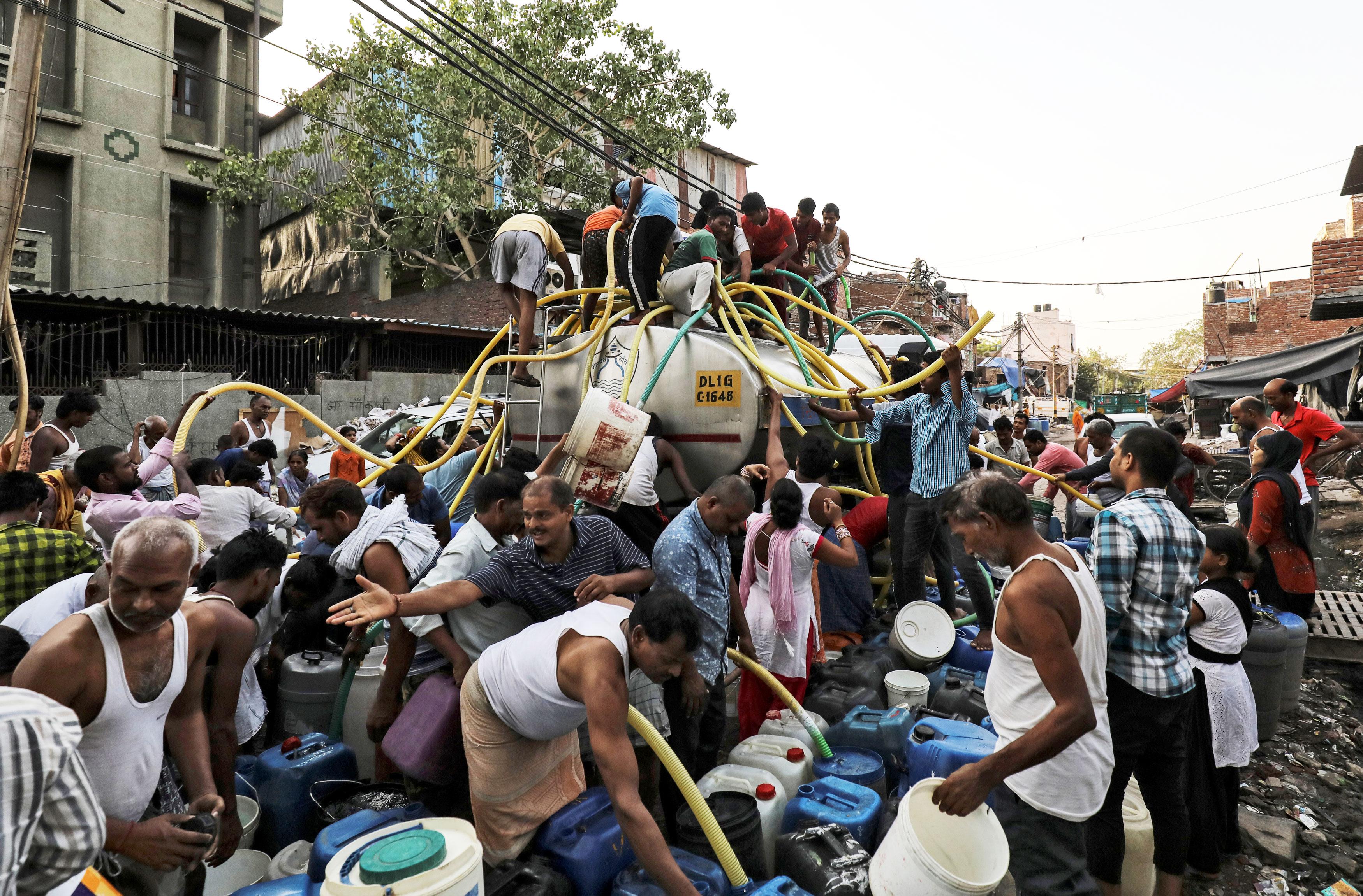 Bildet viser folk som henter vann i en tankbil i India.