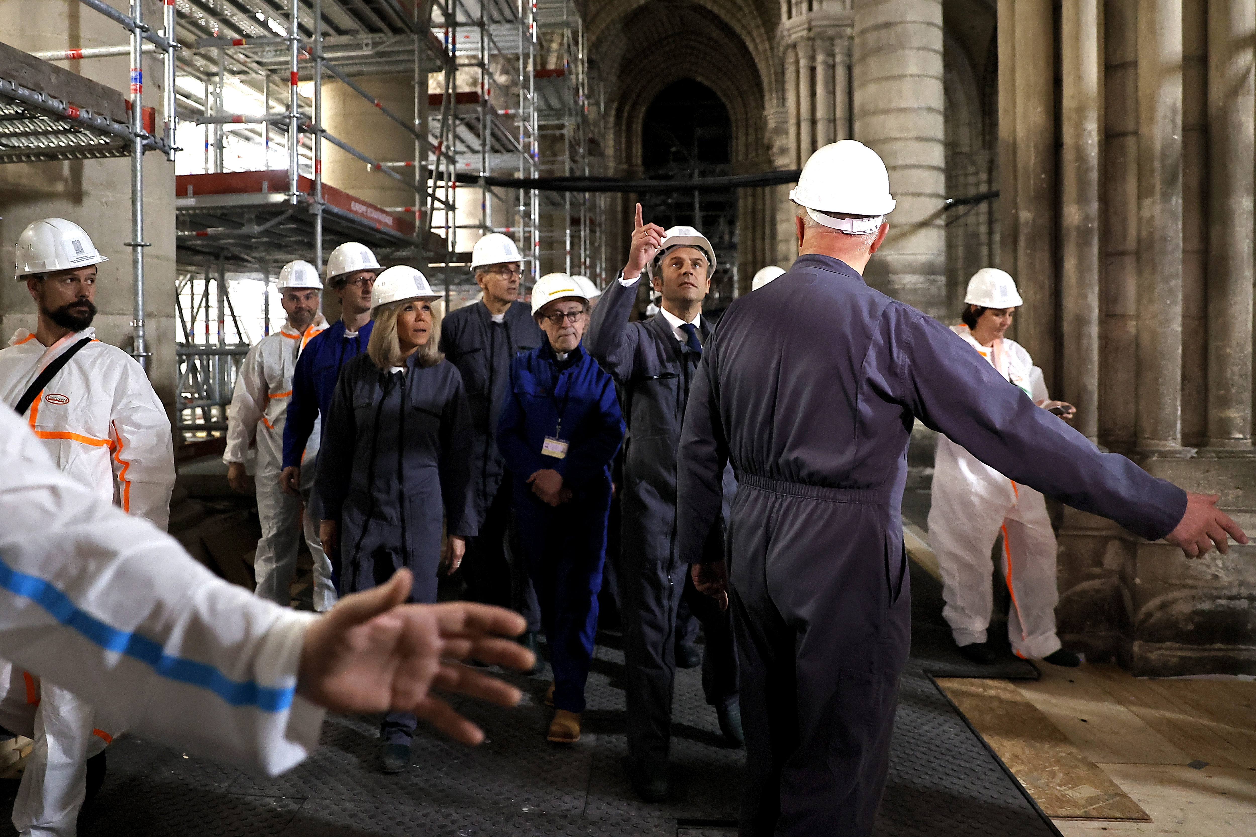 French President Emmanuel Macron and his wife Brigitte Macron, center left, visit the reconstruction site of the Notre-Dame de Paris cathedral, Friday, April 15, 2022 in Paris, to mark three years since the devastating fire. (Ian Langsdon, Pool via AP)