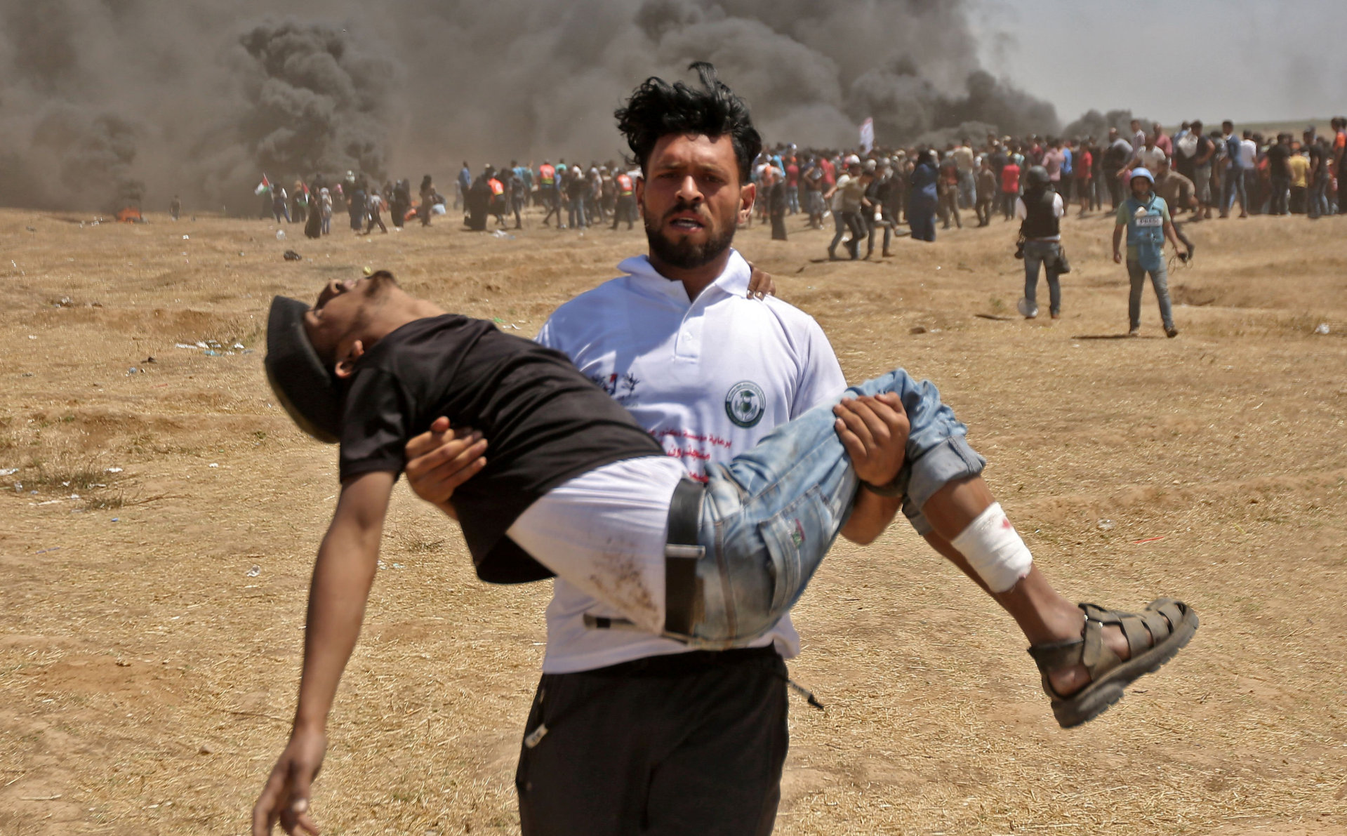 mange sårede: En palestiner bærer en skadet demonstrant under sammenstøtene med israelske soldater i går. FOTO: MAHMUD HAMS / NTB SCANPIX