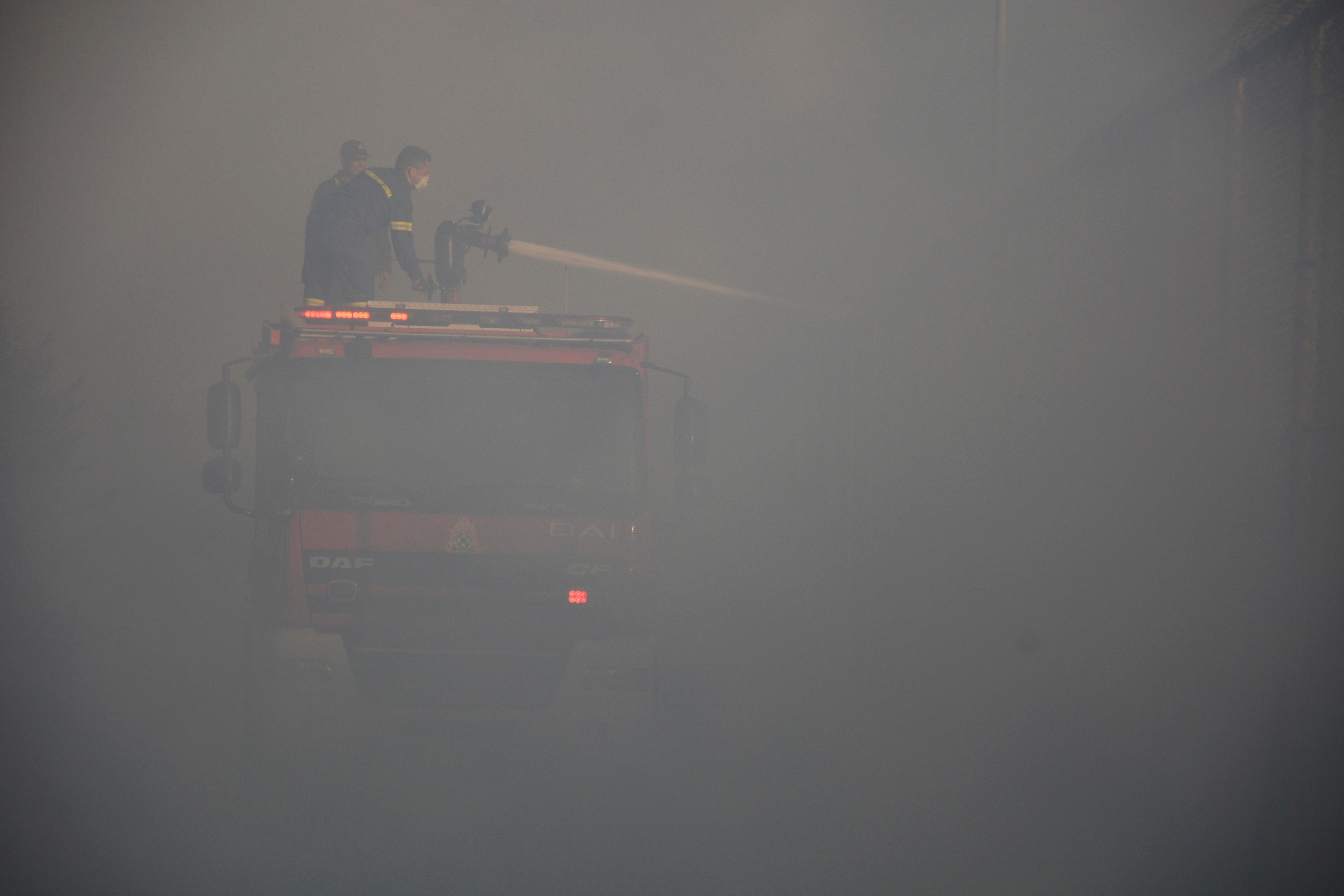 Firefighters try to extinguish a fire in the Moria refugee camp on the northeastern Aegean island of Lesbos, Greece, on Wednesday, Sept. 9, 2020. A fire swept through Greece's largest refugee camp that had been placed under COVID-19 lockdown, leaving more than 12,000 migrants in emergency need of shelter on the island of Lesbos. (AP Photo/Panagiotis Balaskas)