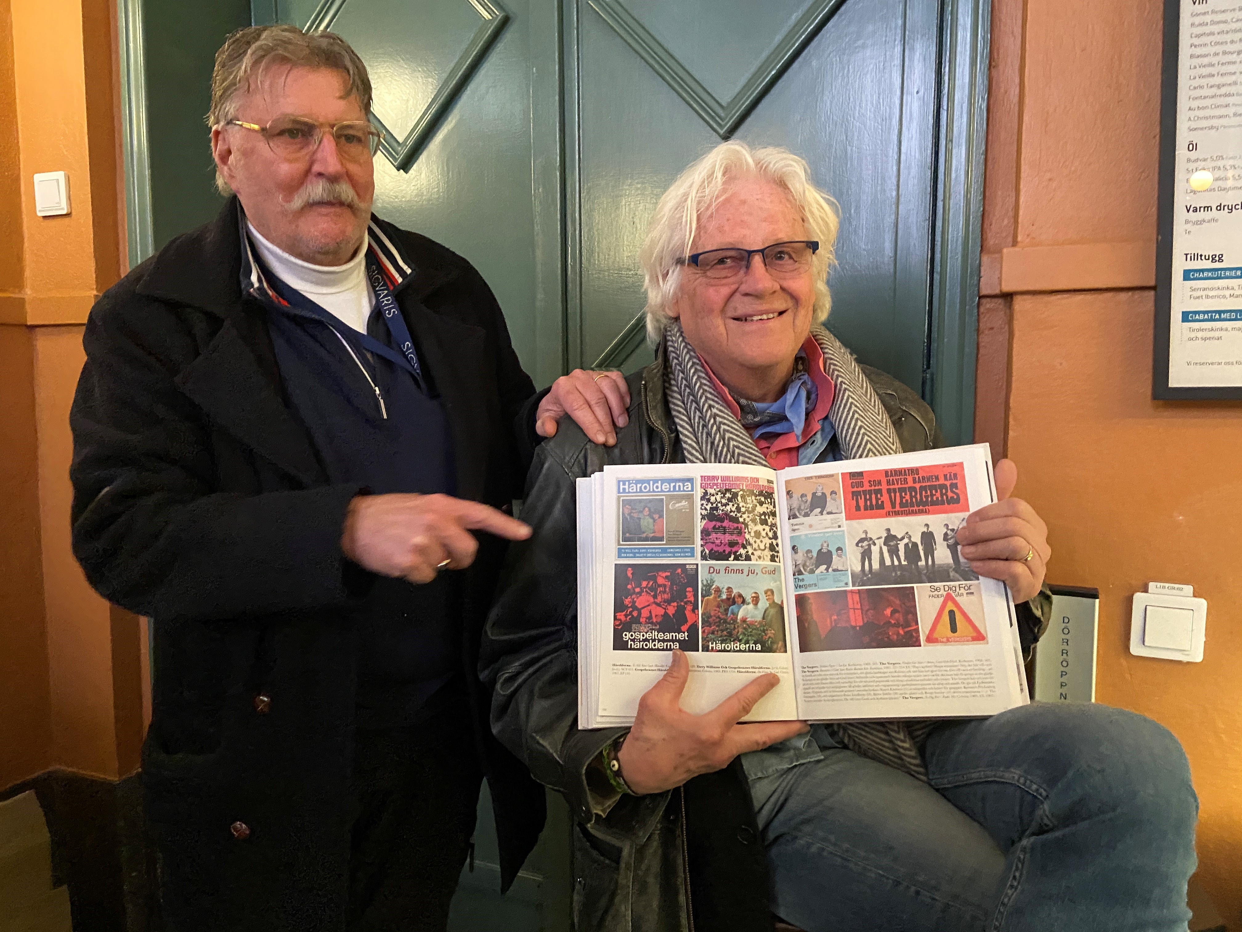 Roger Björklöf och Ludvig Blichfeld från 60-talsbandet The Vergers visar uppslaget med omslagen från deras EP-skivor som finns med i boken "Grammofon-Missionen" med totalt 777 skivomslag från kristna vinylskivor.