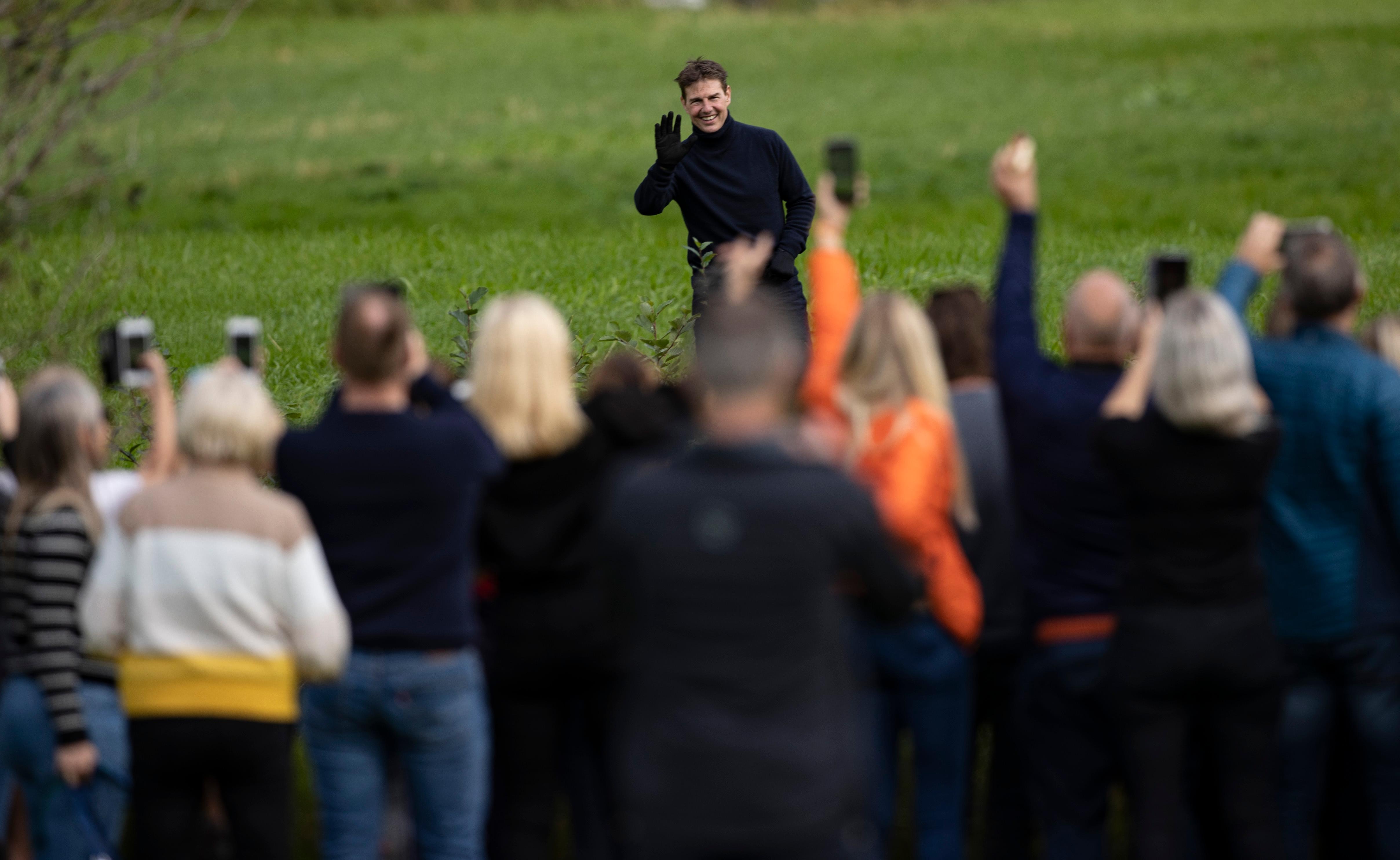 Hellesylt 20200906. 
Skuespiller Tom Cruise hilser og tar farvel med bygdefolket etter at han hadde gjennomført sine halsbrekkende stunt i luften over Hellesylt ved Helsetkopen i anledning av opptakene av den neste «Mission: Impossible»-filmen. Etter flere dagers venting gjennomførte actionhelten fire hopp med motorsykkel ut fra den enorme rampen på fjelltoppen Helsetkopen ved Hellesylt i Stranda Kommune. Syklene landet i ura, mens Cruise svevet ned den bratte fjellsiden i fallskjerm.
Foto: Geir Olsen / NTB scanpix